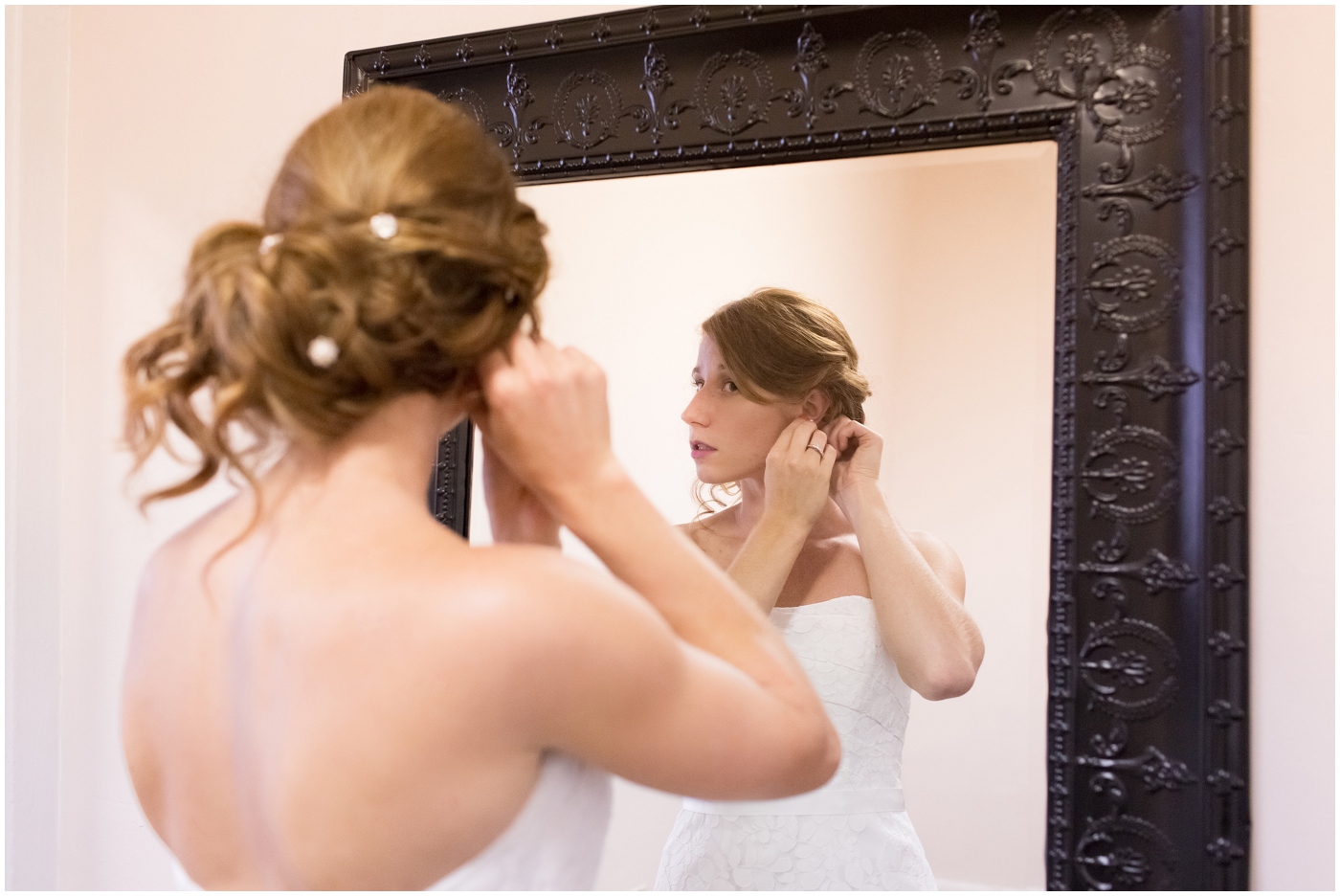 picture of bride putting earrings on
