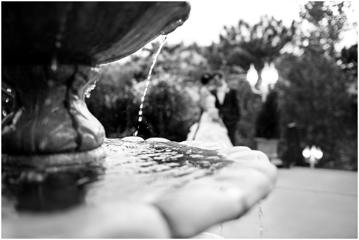 picture of bride and groom by a fountain