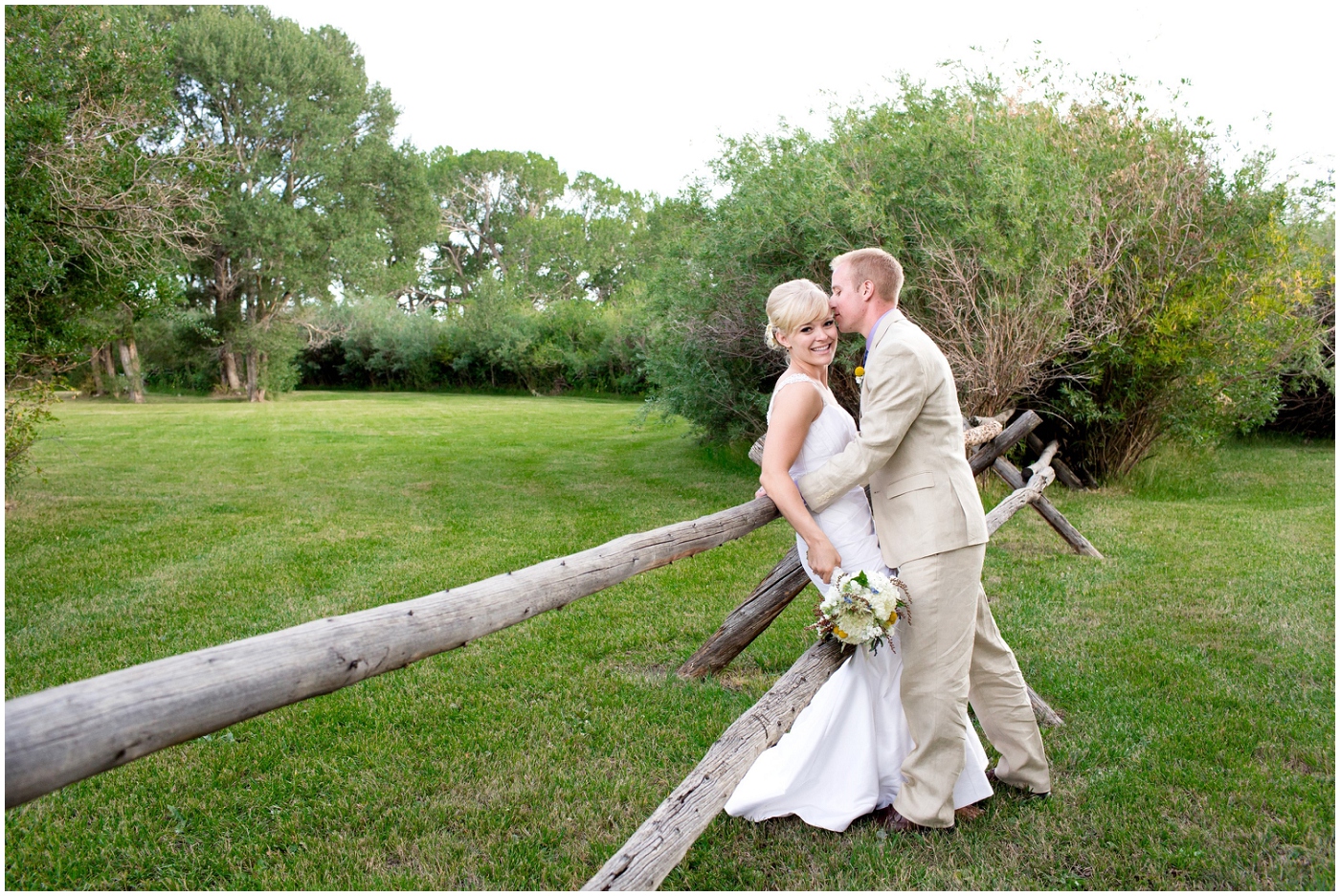 picture of a bride and groom against rustic fence