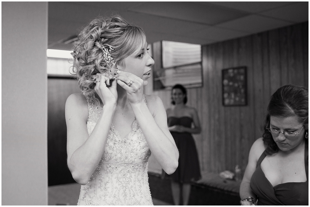 picture of a bride putting earrings on