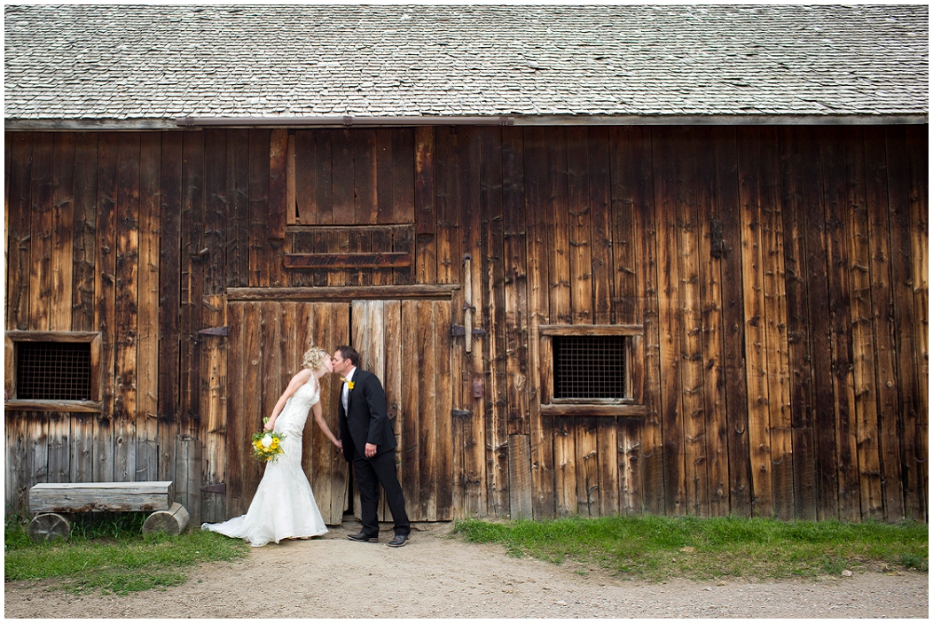 picture of bride and groom against a barn