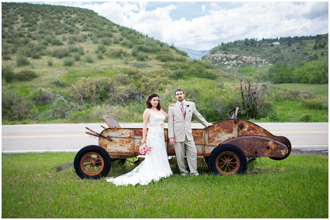 picture of bride and groom with old vehicle