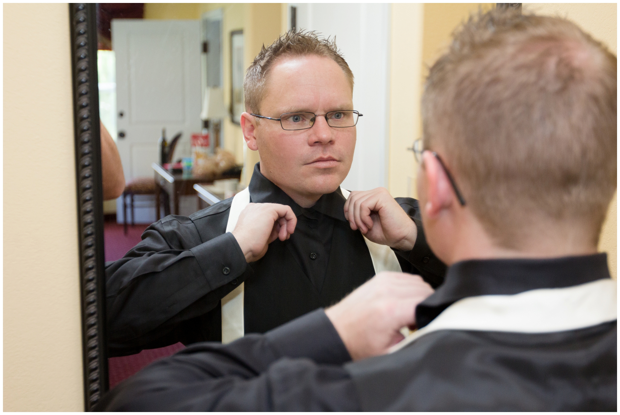 picture of groom putting his tie on