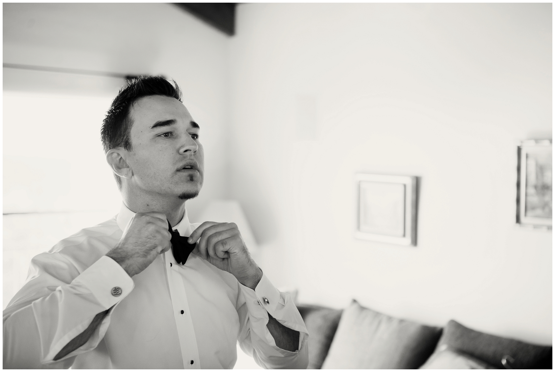 picture of groom putting on a bowtie