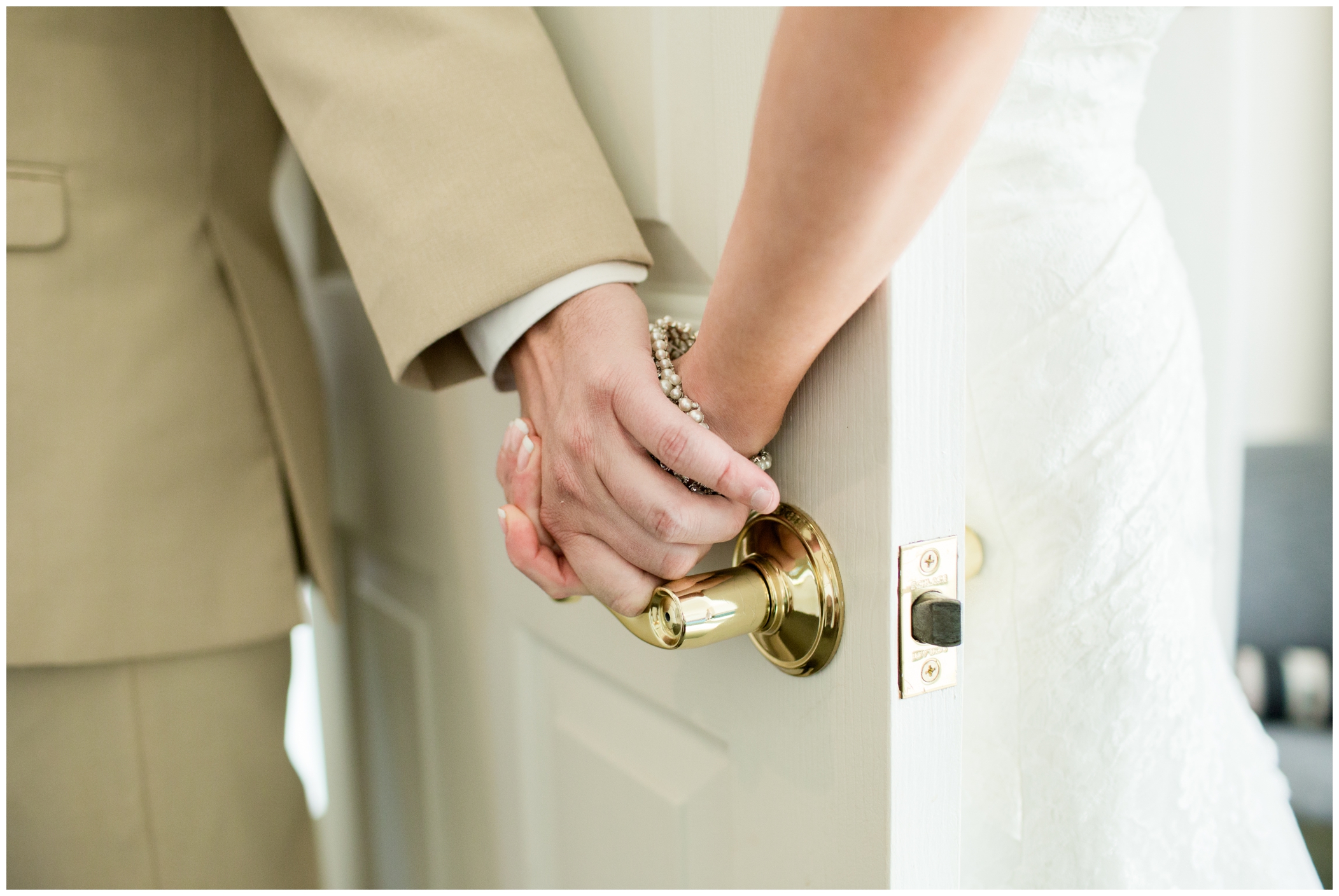 picture of bride and groom holding hands behind a door 