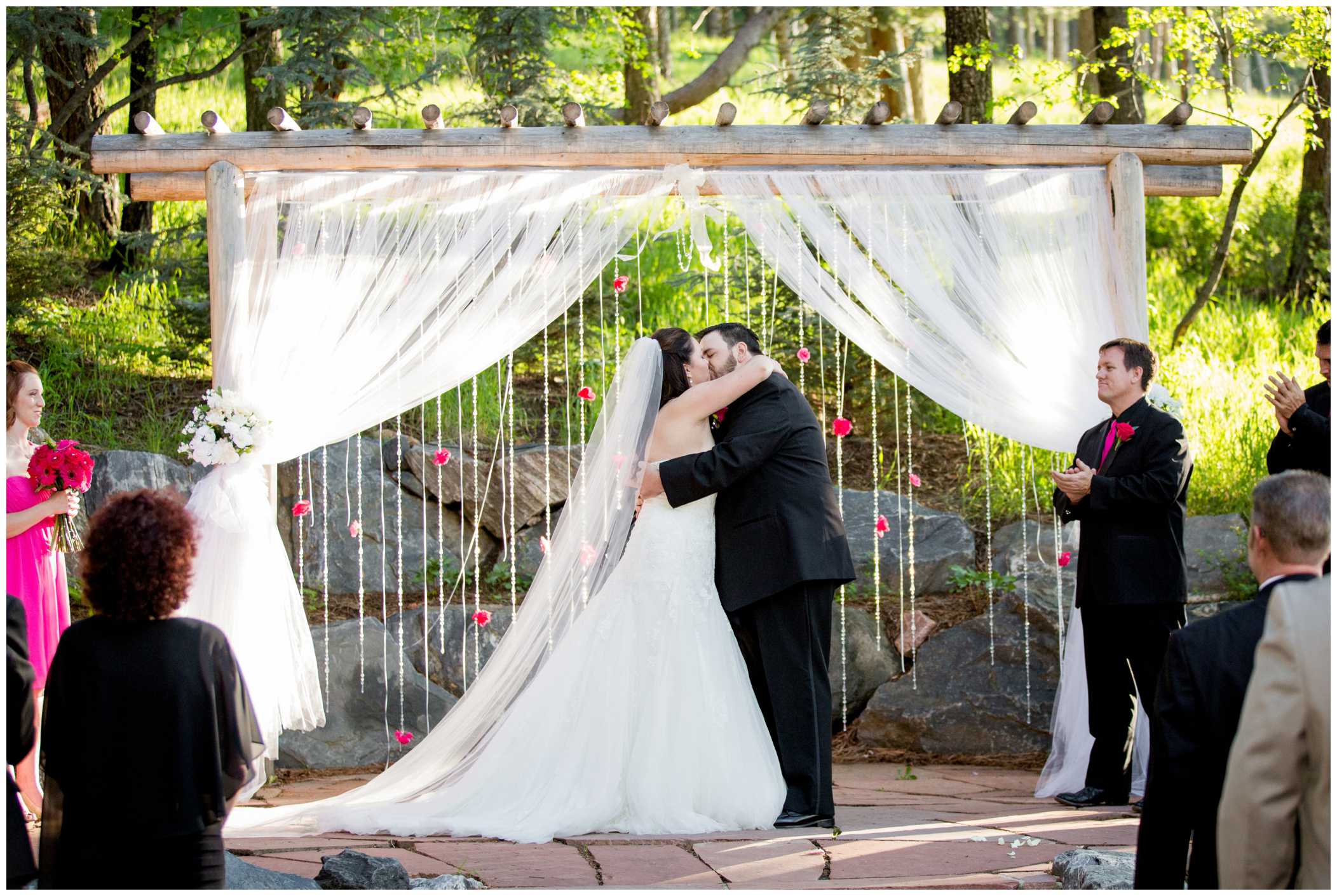 picture of first kiss during Colorado forest wedding 