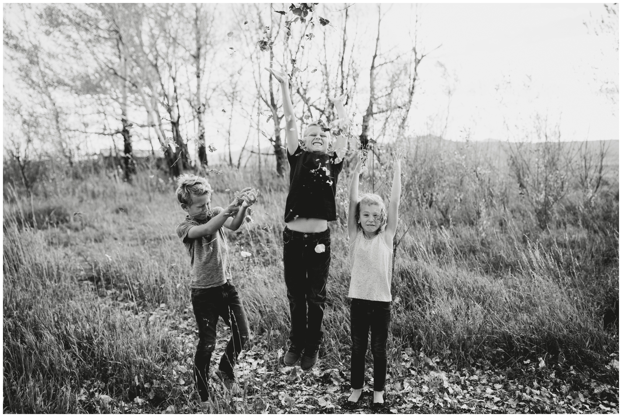 kids throwing leaves during Longmont Colorado family pictures 