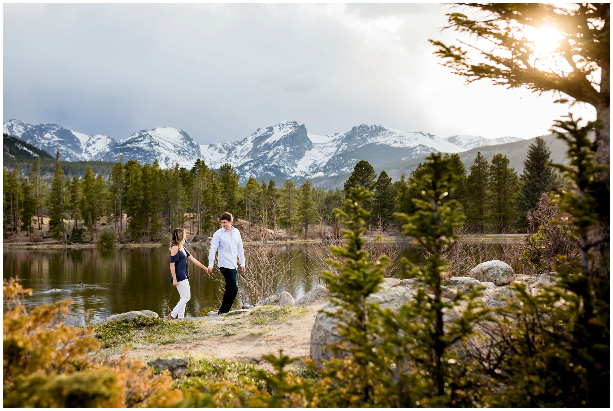 couple walking at Sprague Lake during their RMNP engagement portraits 
