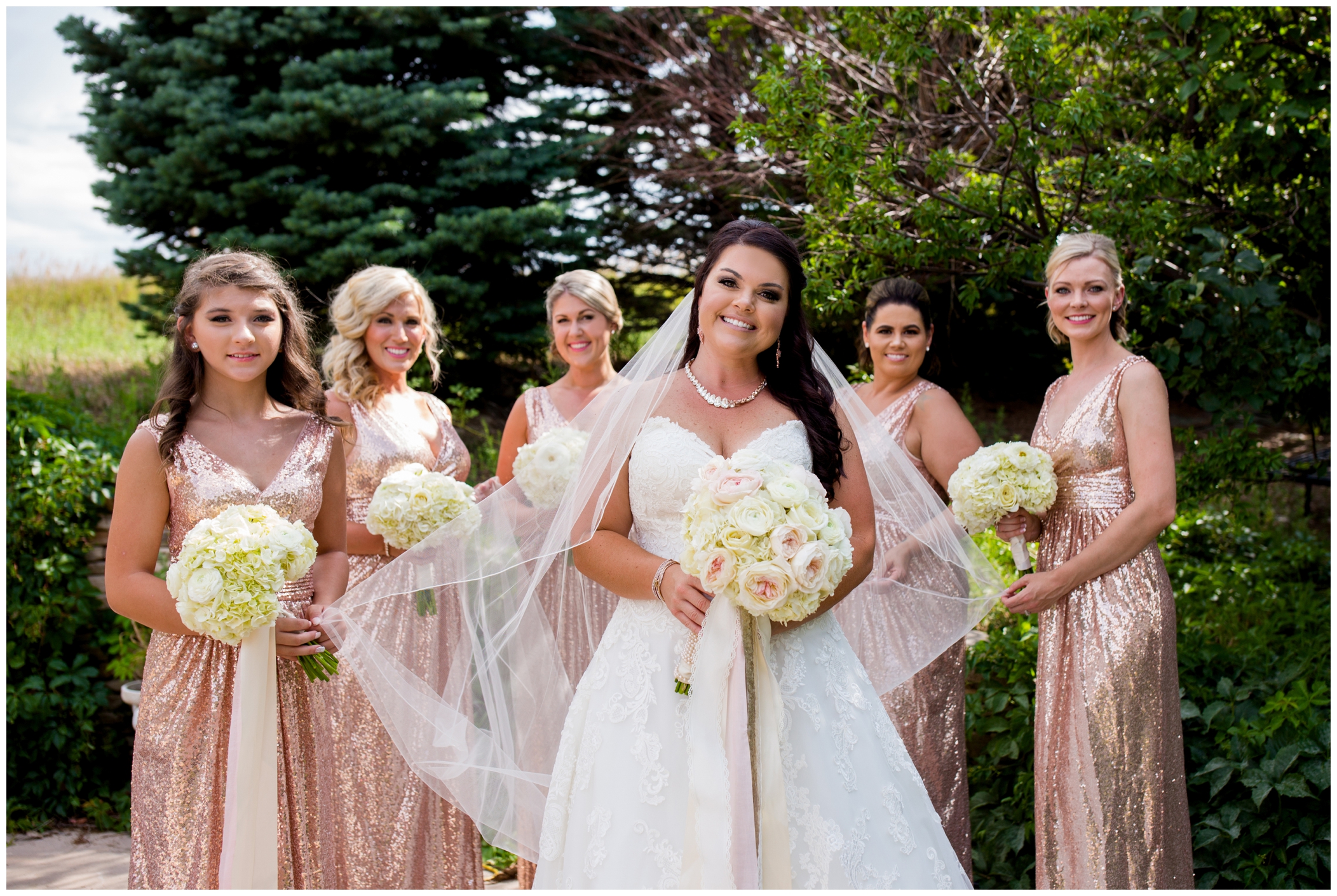 bridesmaids holding bride's veil during Stonewall Farms wedding photos