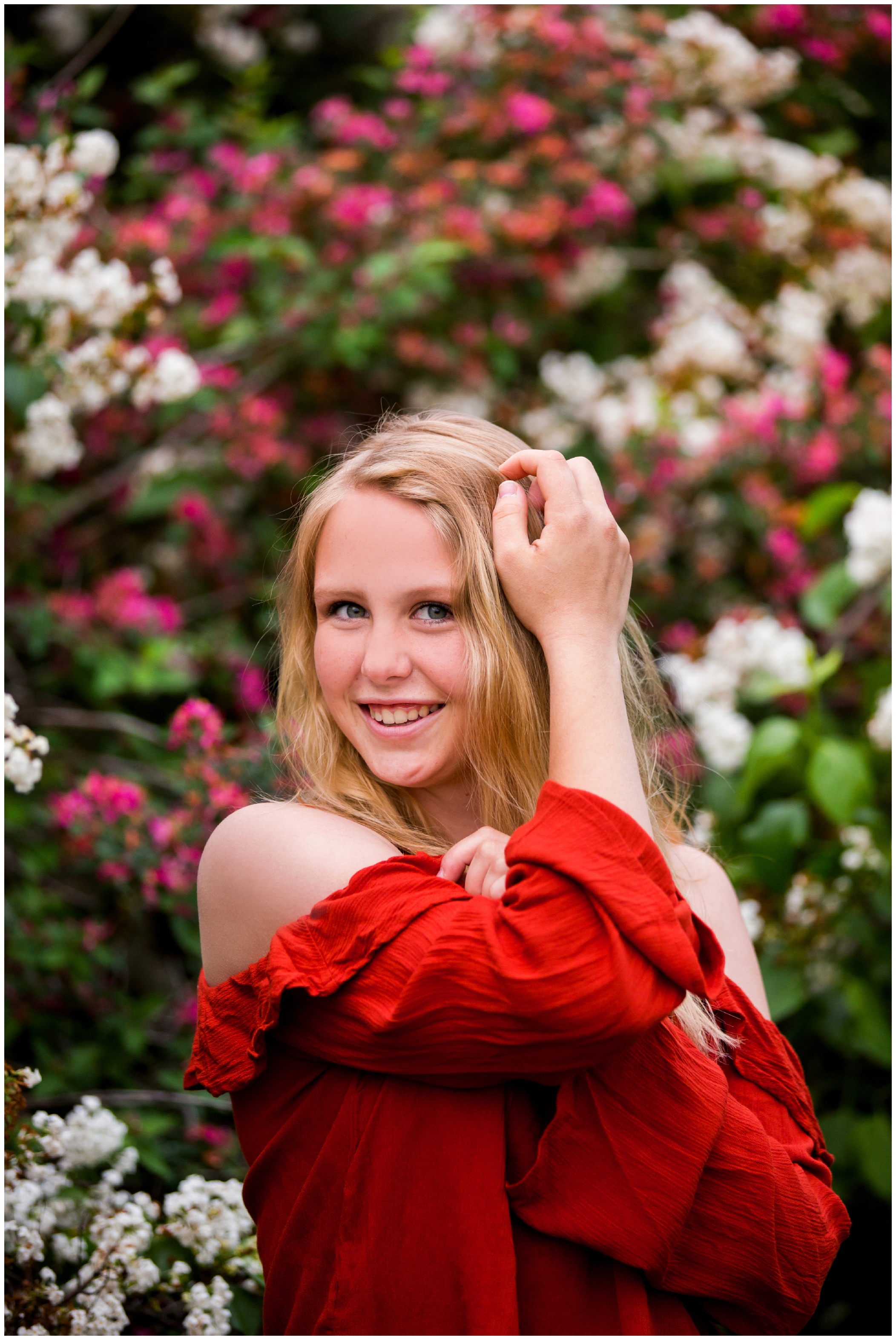 teen posing against pink and white flowers during Longmont Colorado senior photos 