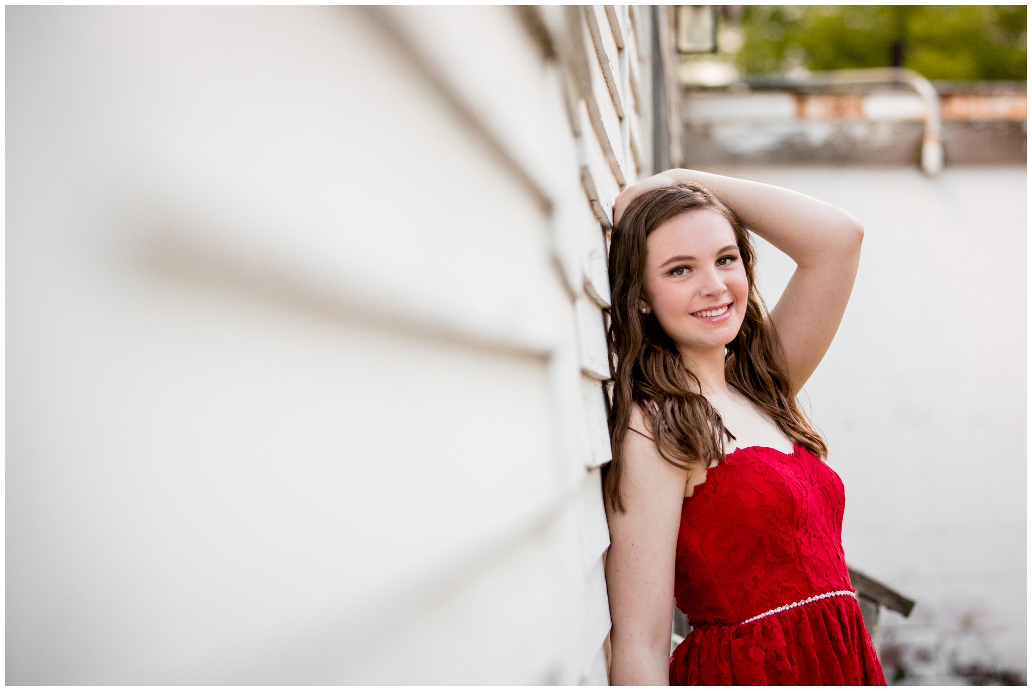 girl leaning against white house during silver creek senior pictures longmont