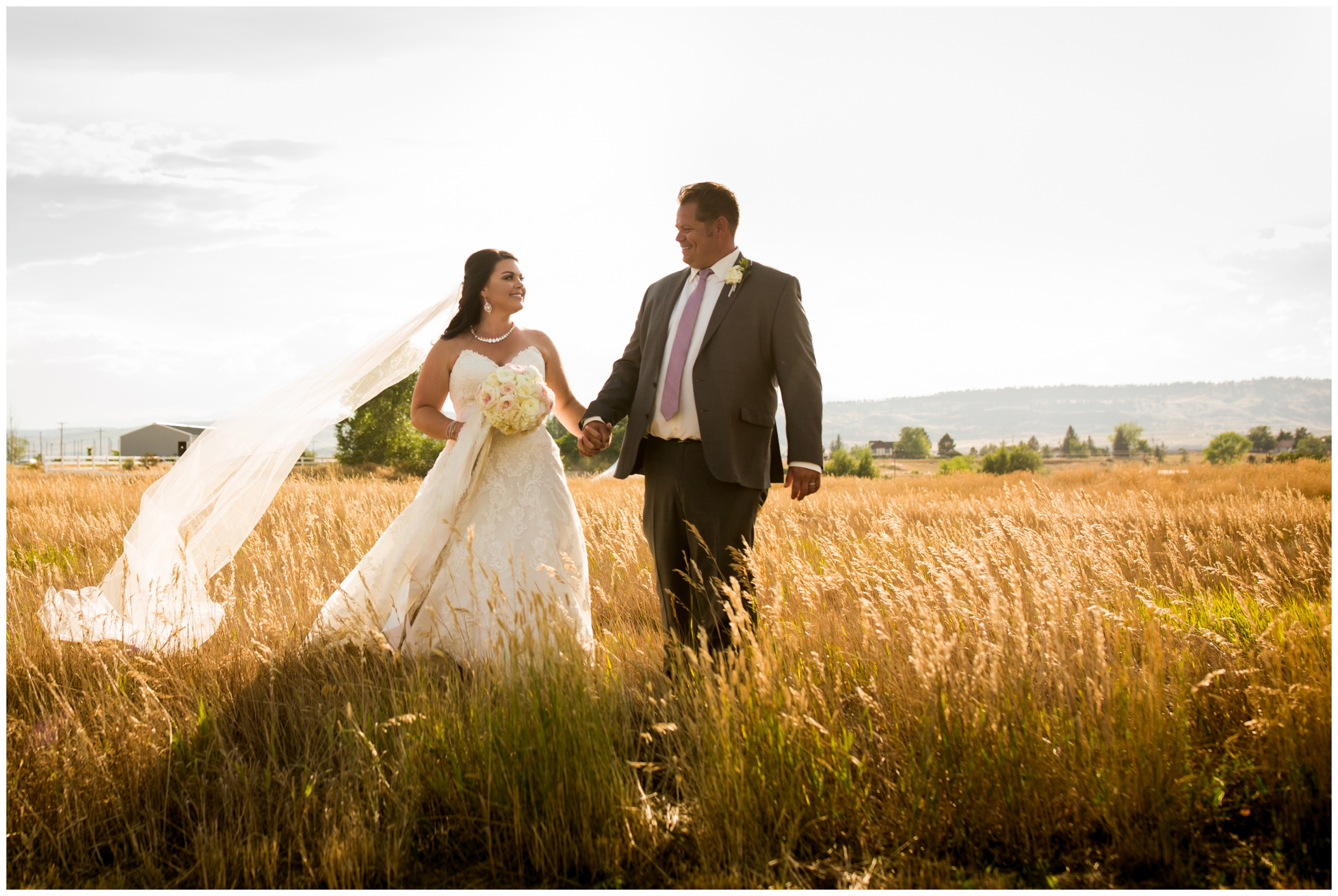 bride and groom walking through a field during Stonewall Farm Berthoud wedding portraits 