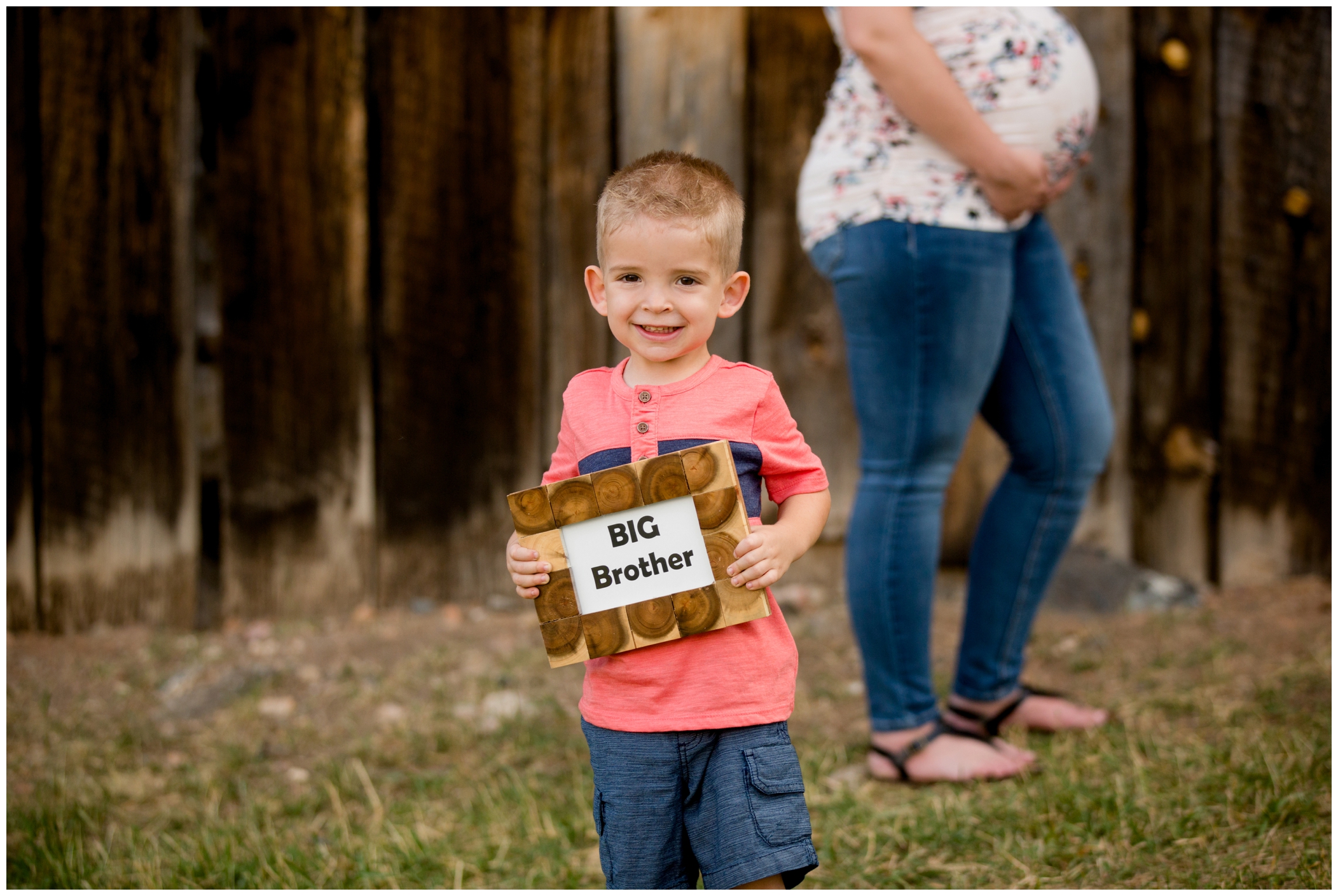 boy holding big brother sign at Evergreen Colorado family maternity pictures at Alderfer/Three Sisters Park by portrait photographer Plum Pretty Photography