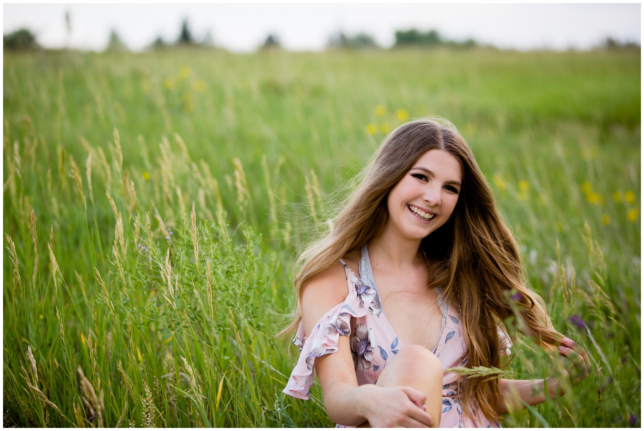 girl sitting in a field during Westminster senior pictures 