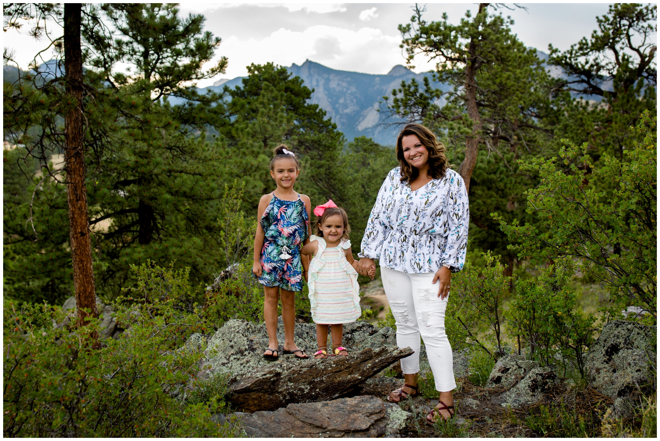 mom and daughters posing with mountains in background during estes park colorado family portraits 