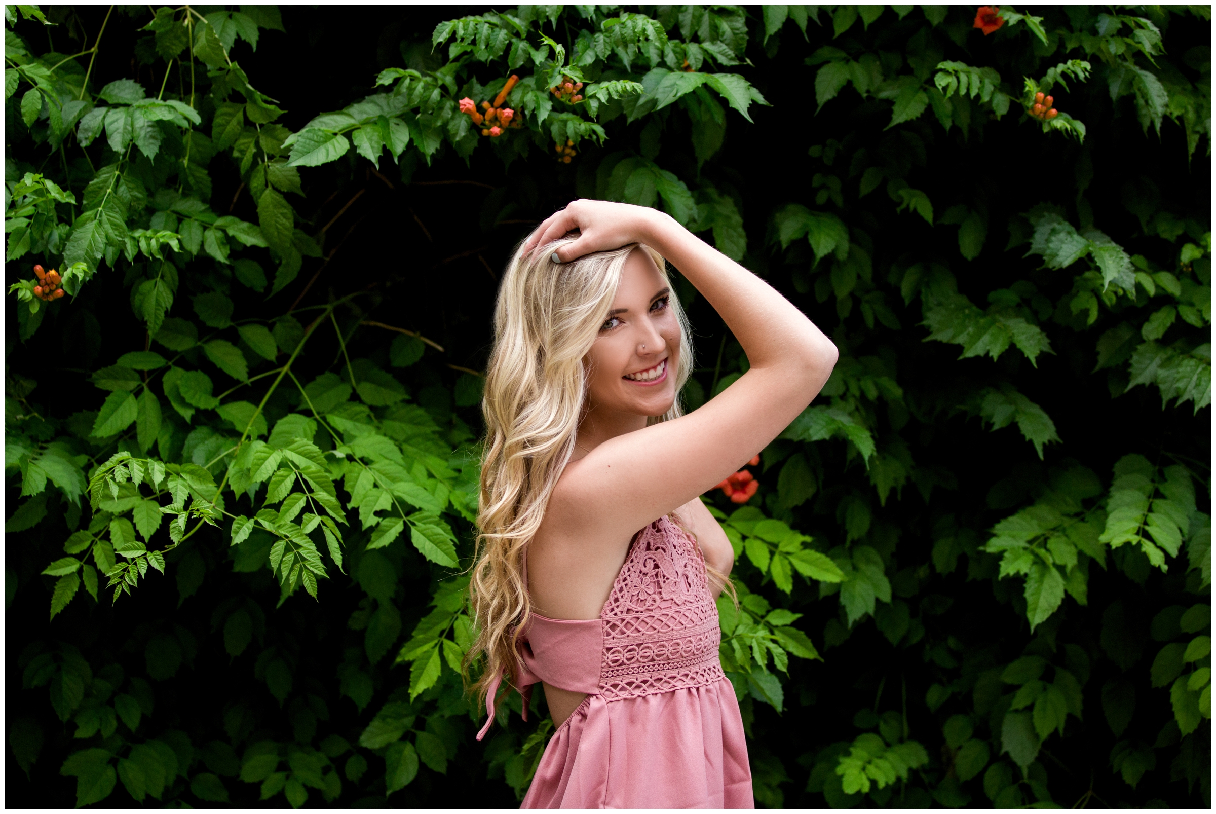 girl posing in front of flower wall at Longmont Colorado senior photography session 