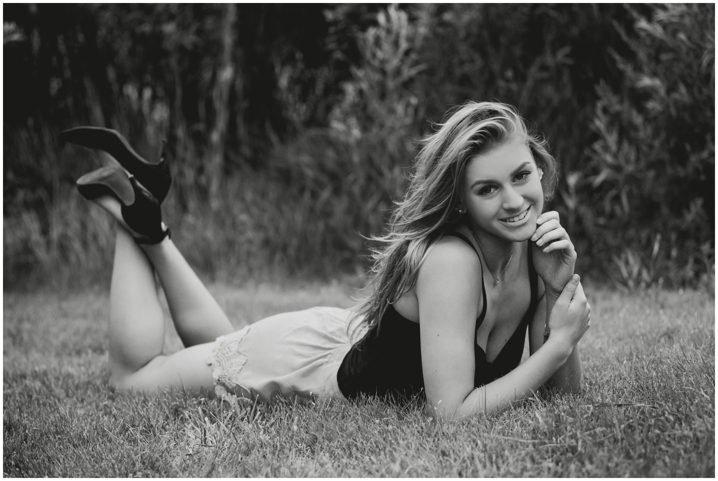 girl laying in grass during Longmont Colorado senior pictures 
