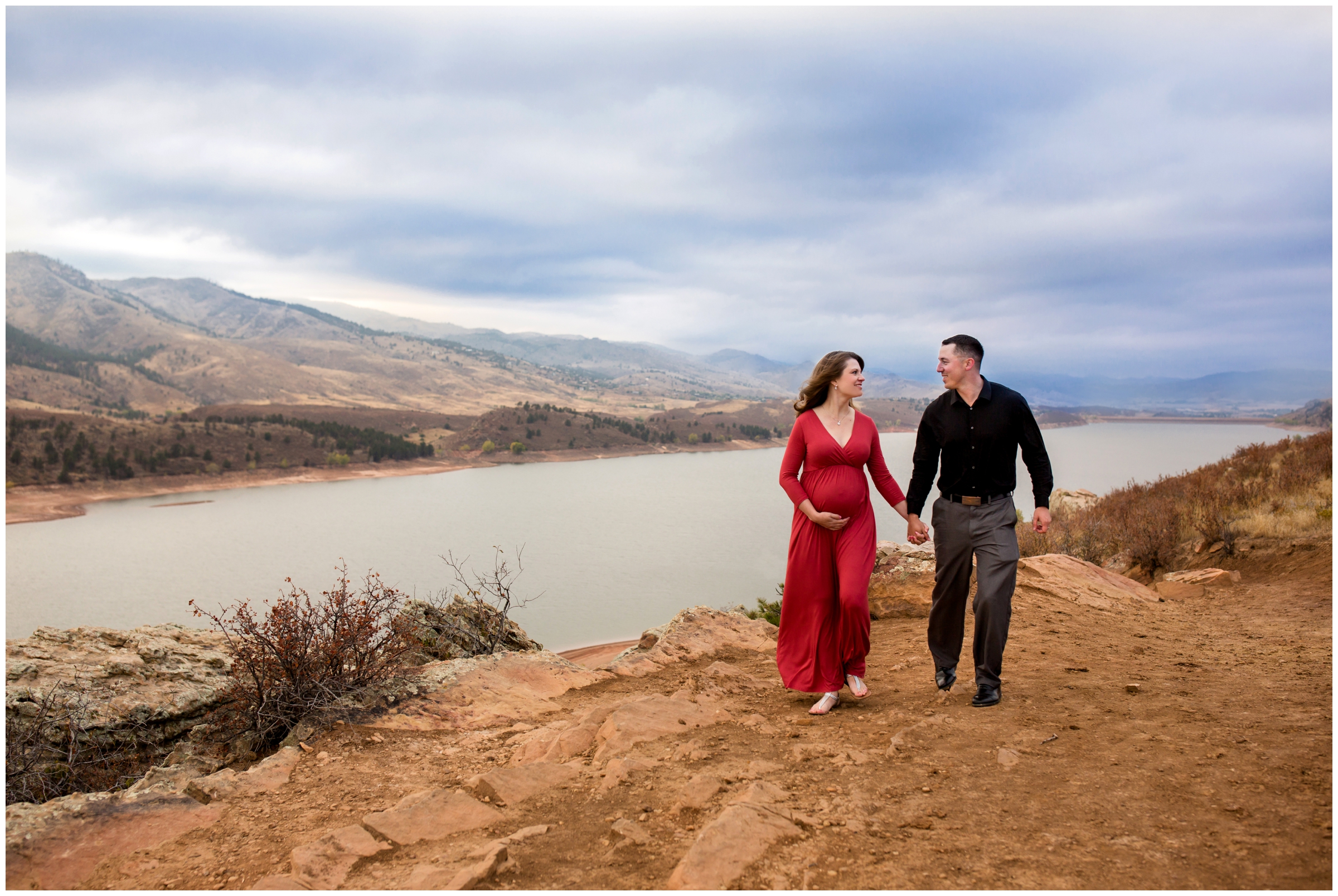 couple walking with mountains in background at Horsetooth Reservoir Ft Collins maternity photography session 