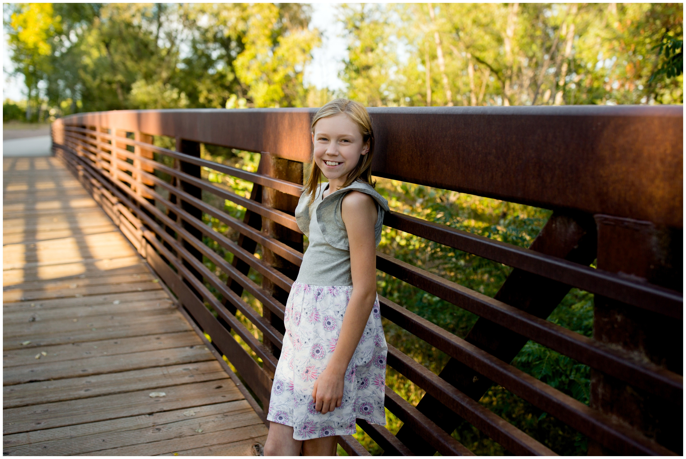young girl posing on bridge at Golden Ponds during Longmont Colorado family photos during fall 