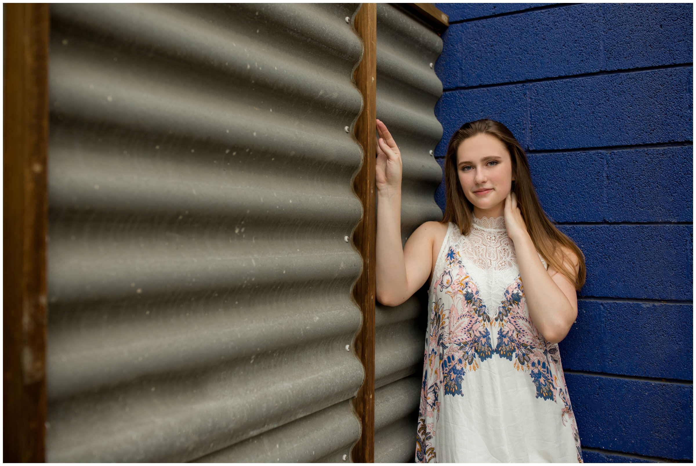 teen girl leaning against blue wall at Boulder Colorado senior pictures 
