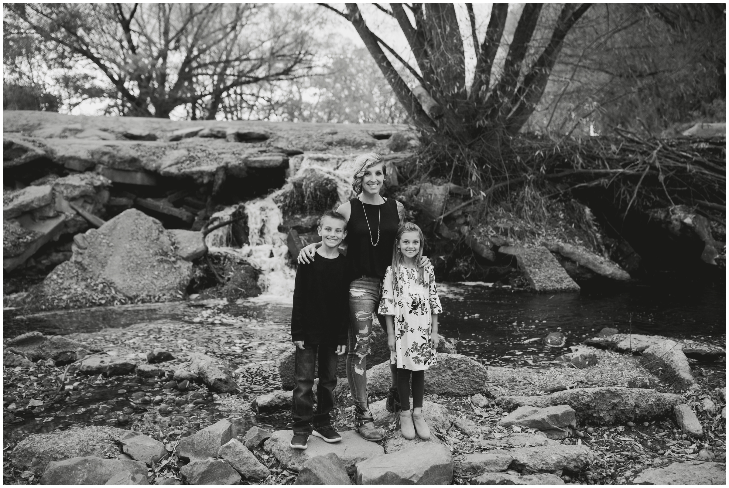 mom and children standing in front of waterfall at Golden Ponds