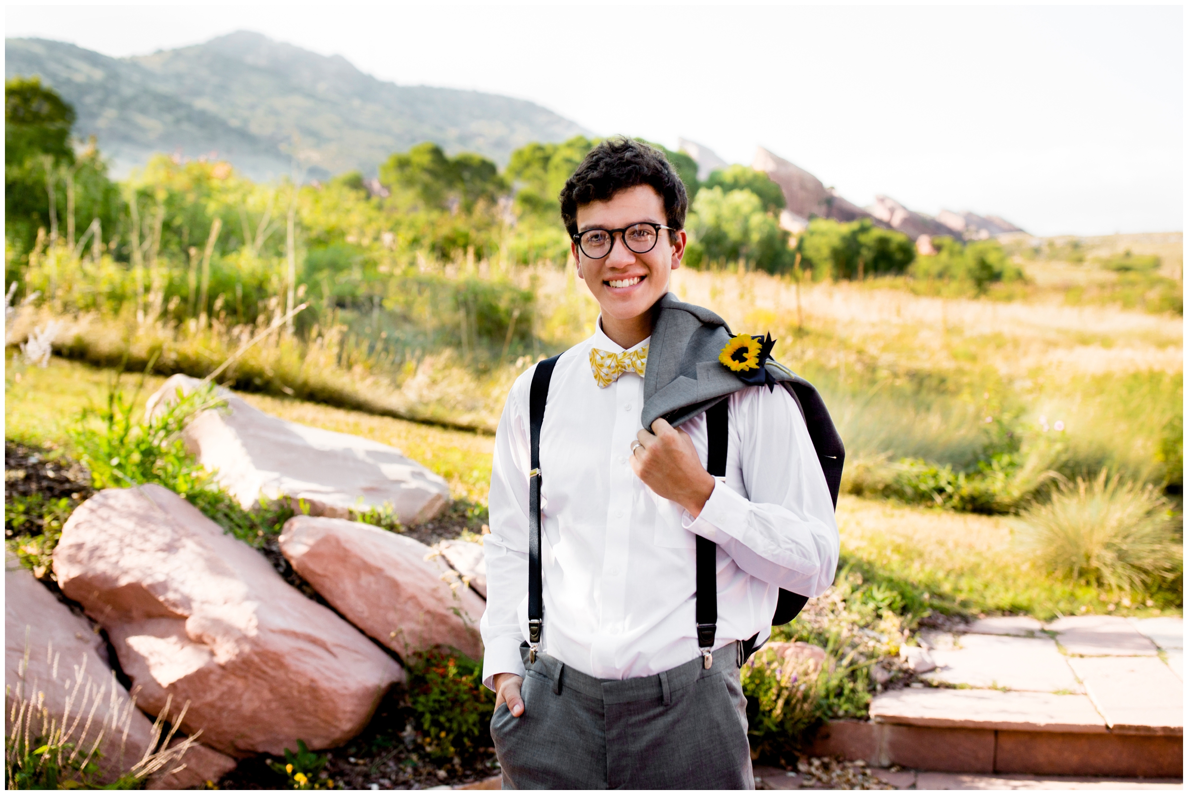 groom posing with red rocks in background at Red Rocks Chapel wedding