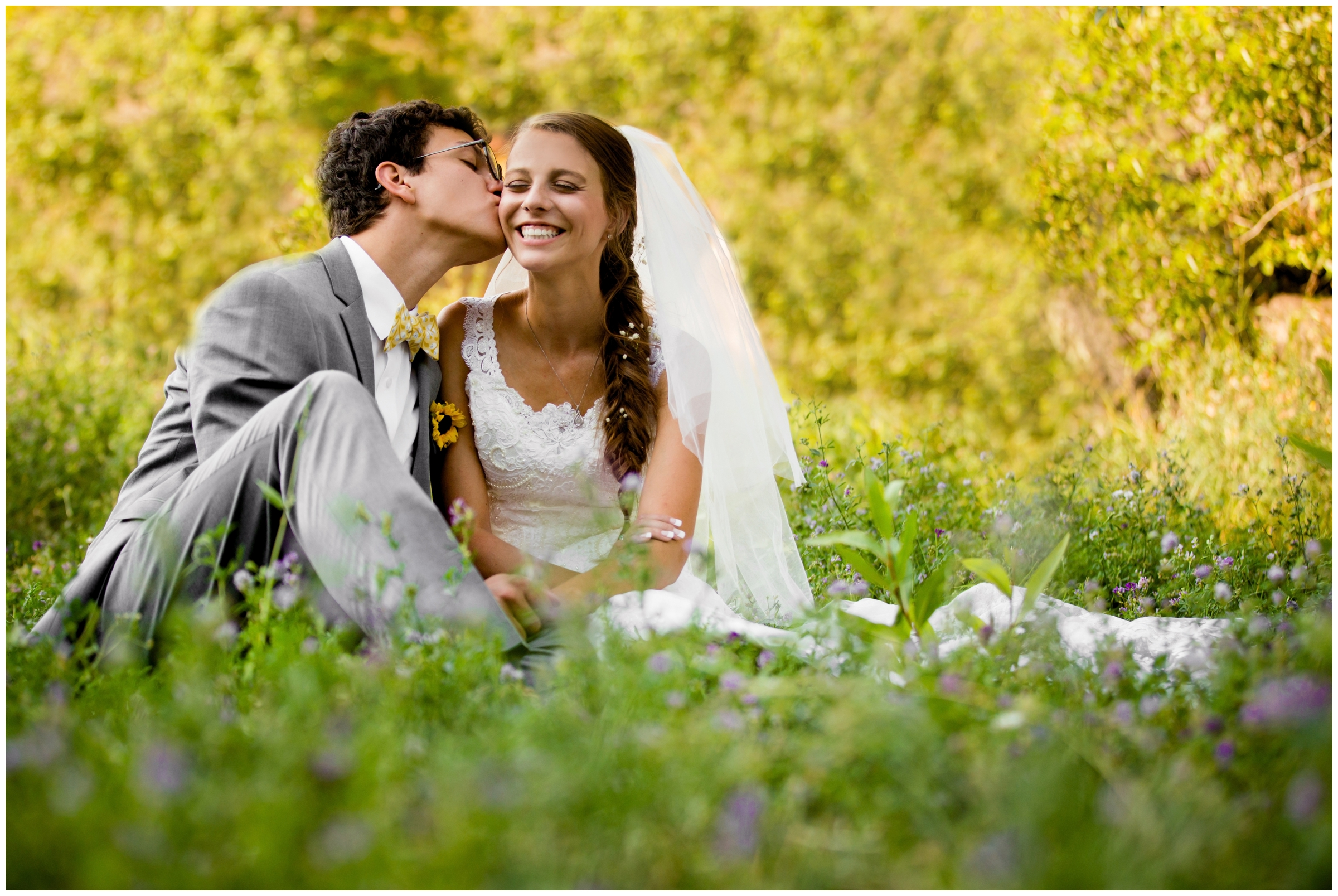 couple sitting in wildflowers at Golden Colorado wedding