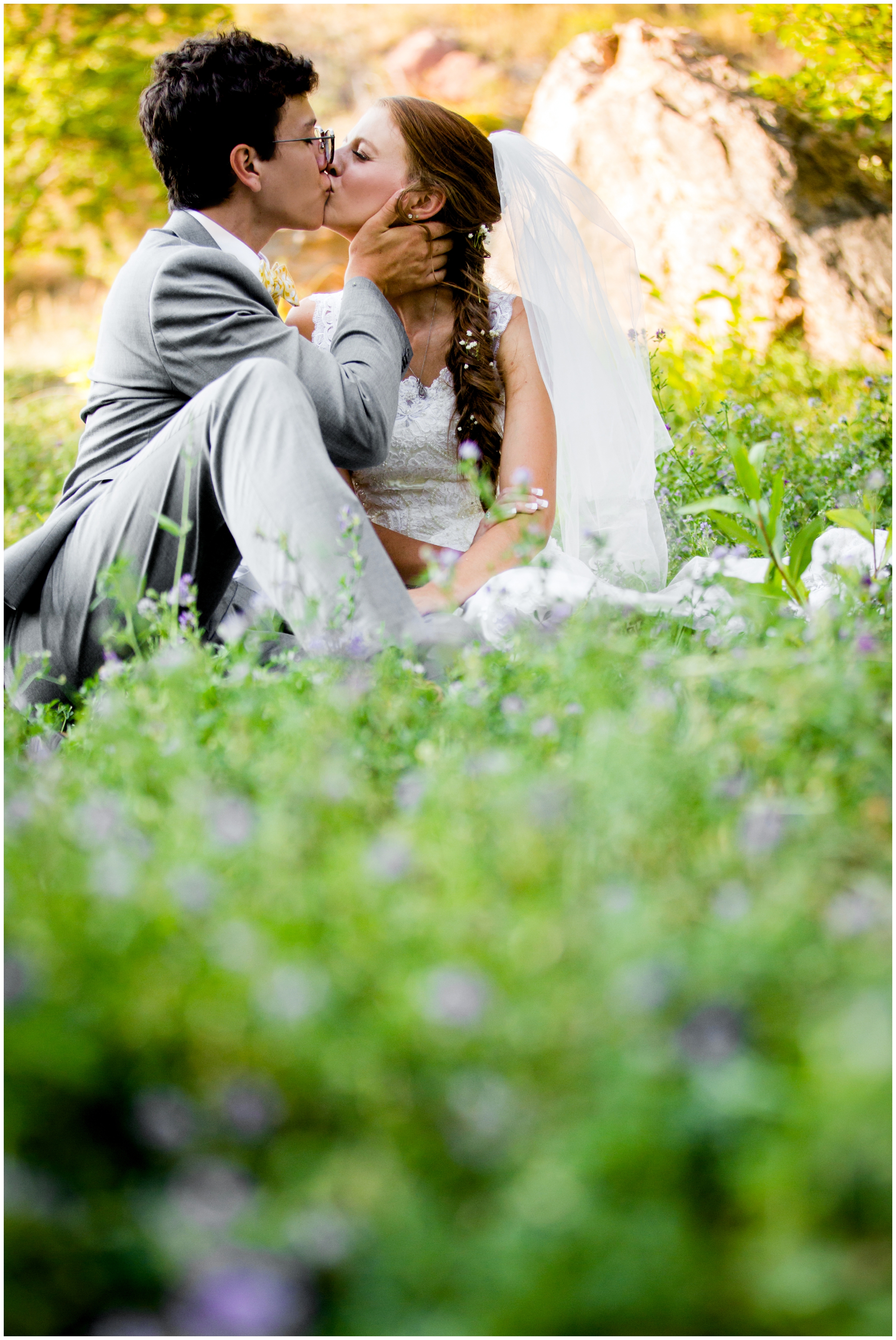 couple sitting in wildflowers during Colorado mountain wedding photography session 