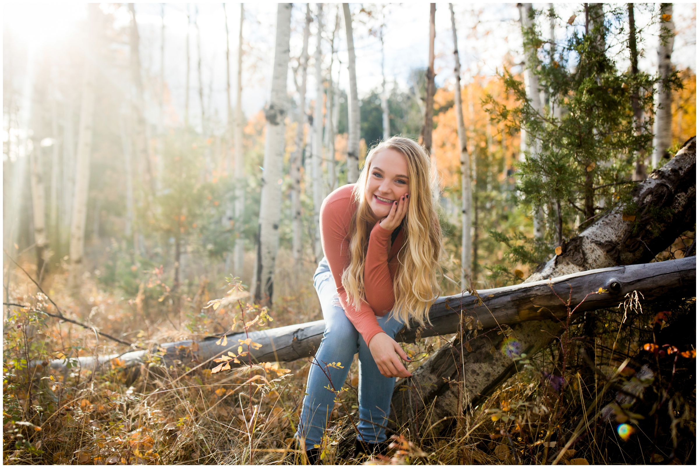 girl sitting on fall tree trunk at Gross Reservoir Colorado senior photos 