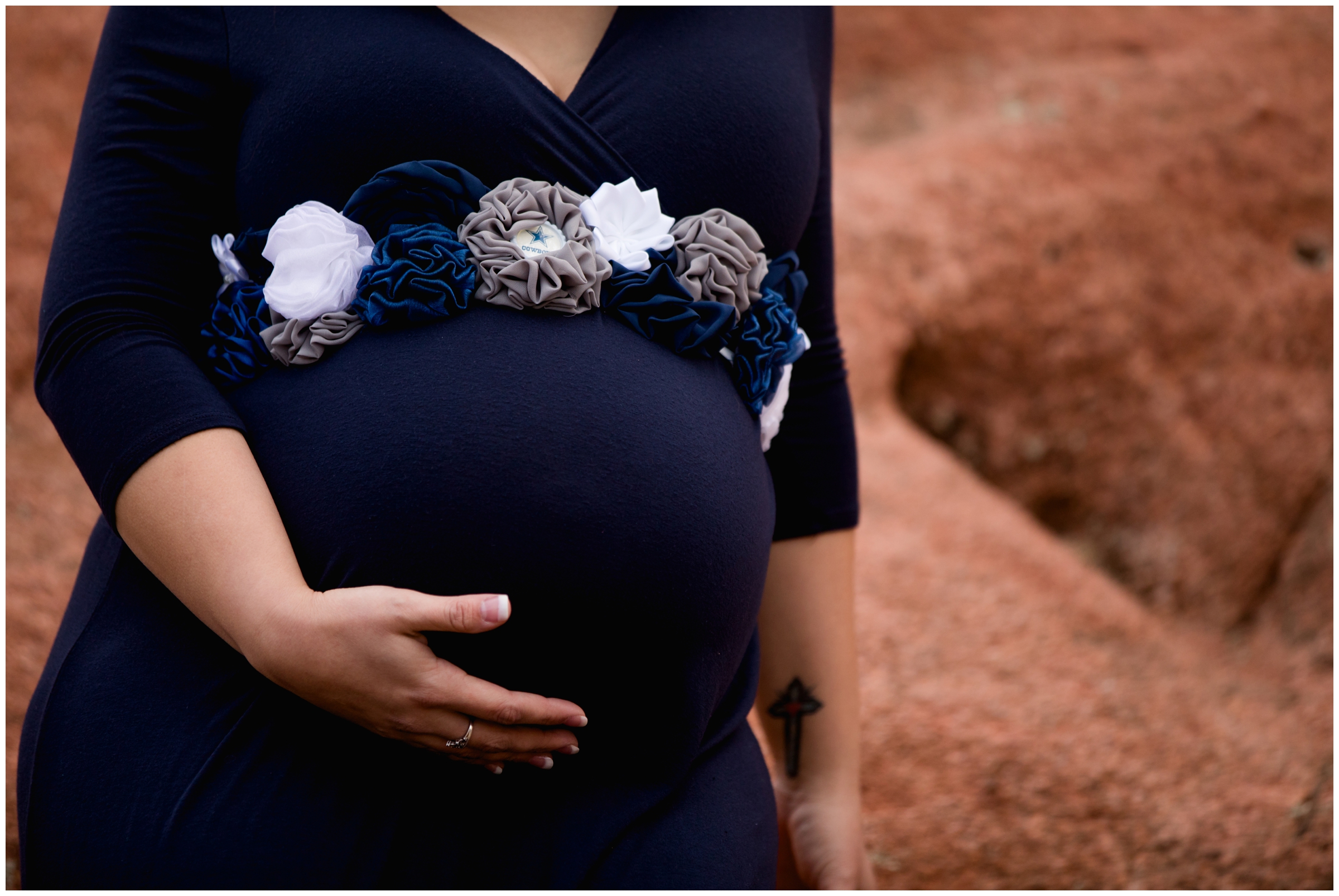 pregnant woman in navy blue dress and Dallas Cowboys flower sash 