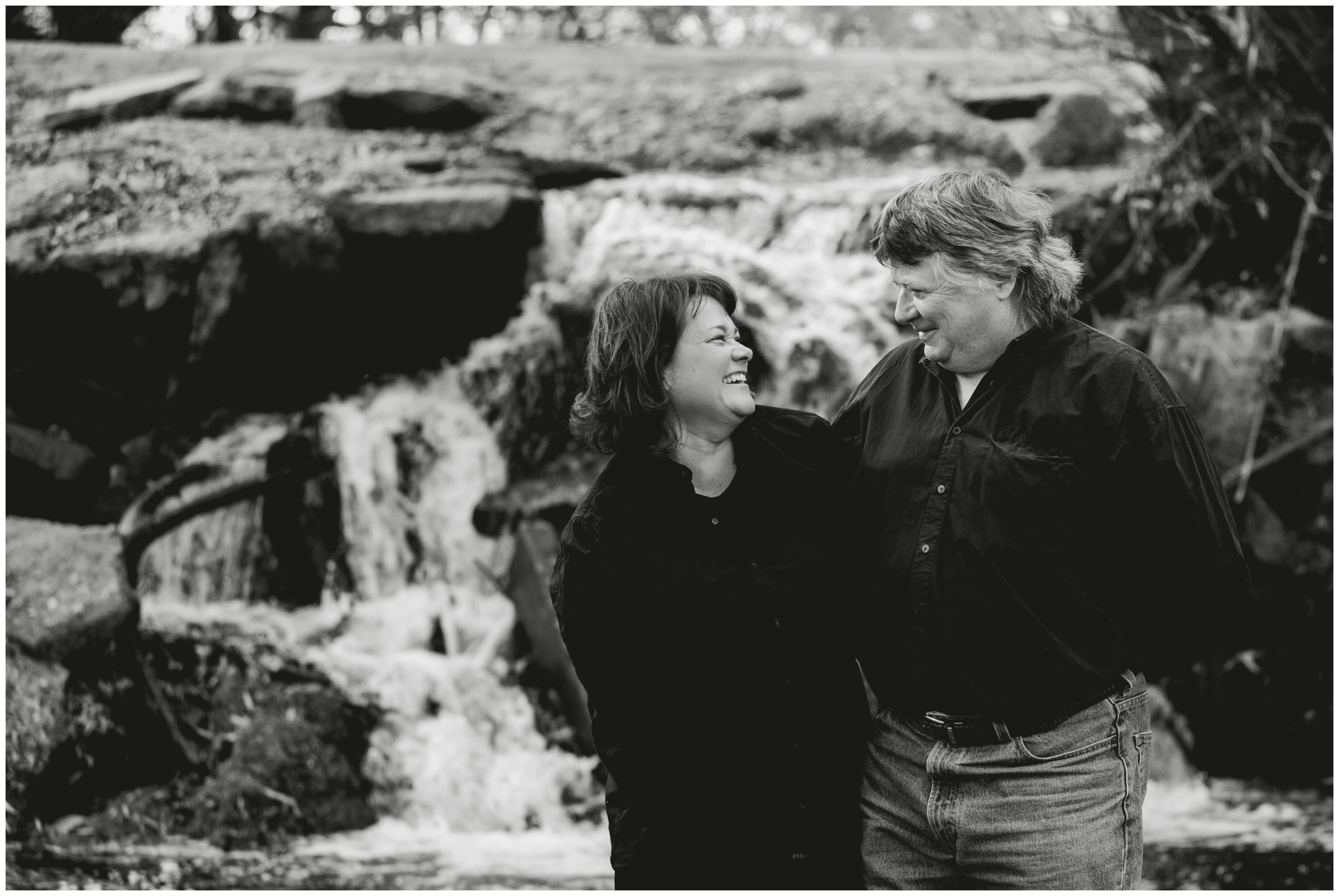 couple laughing with waterfall in background in Longmont Colorado 