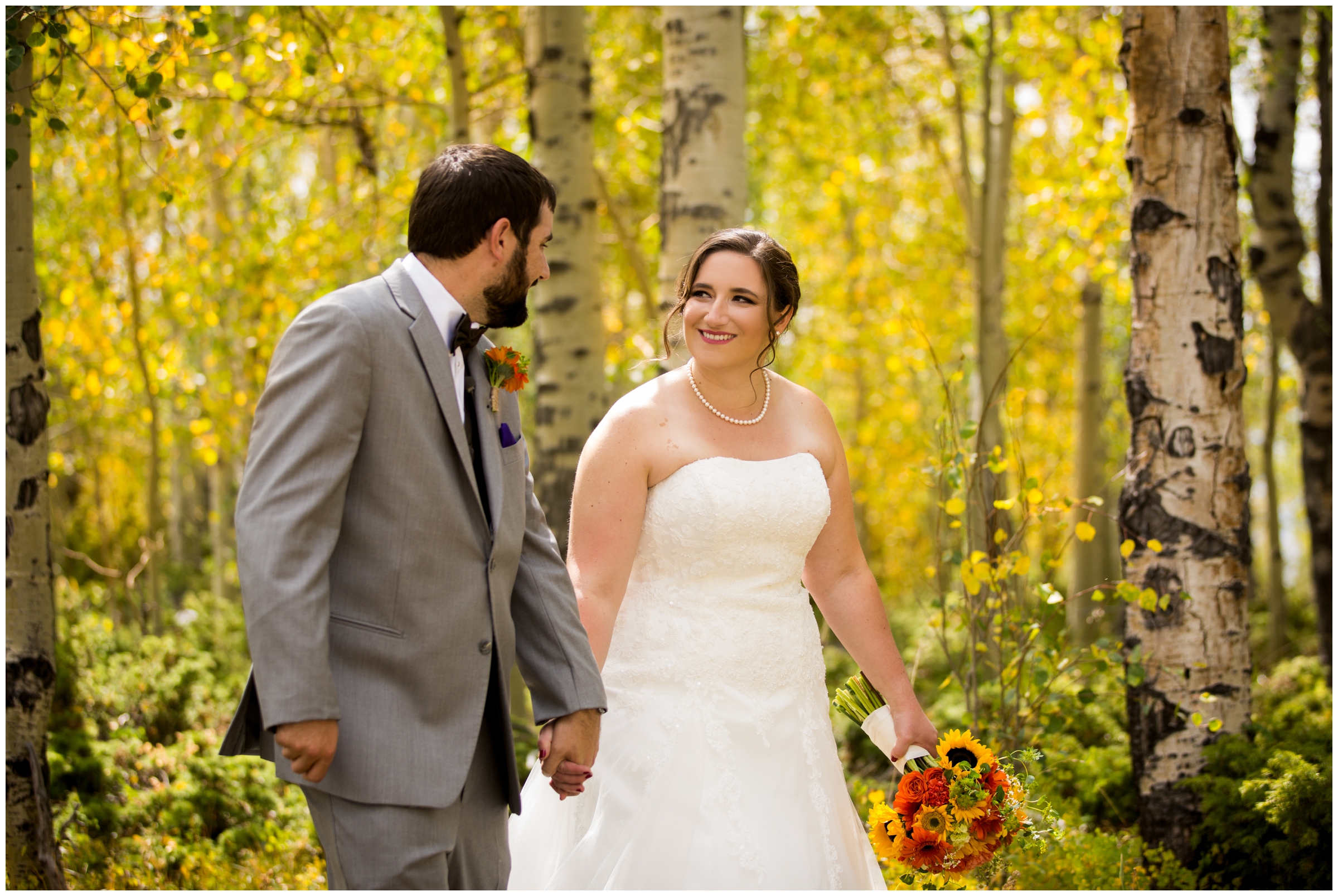 couple walking in aspen grove at Colorado fall wedding in Granby mountains 