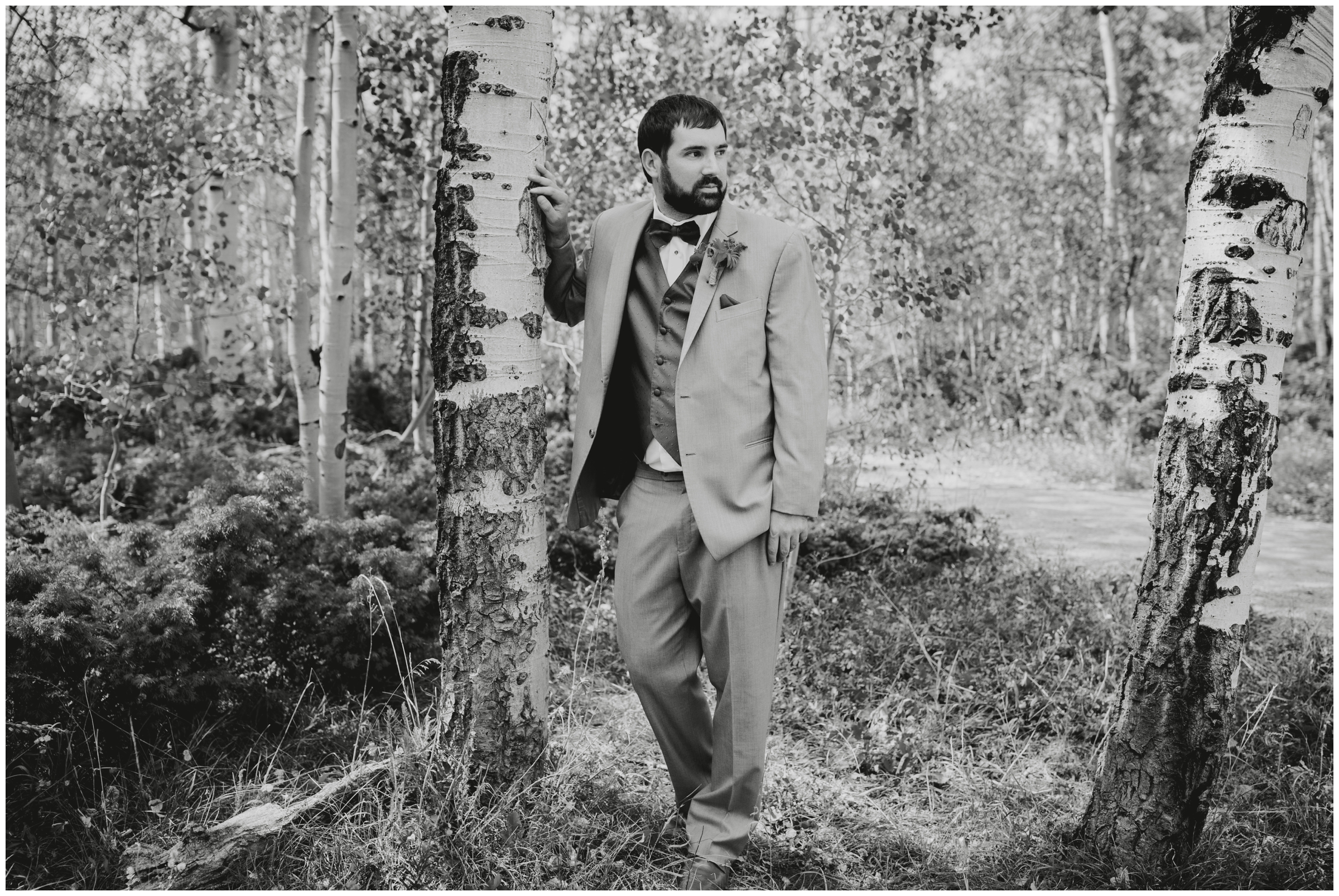 groom posing against a tree at Colorado mountain wedding