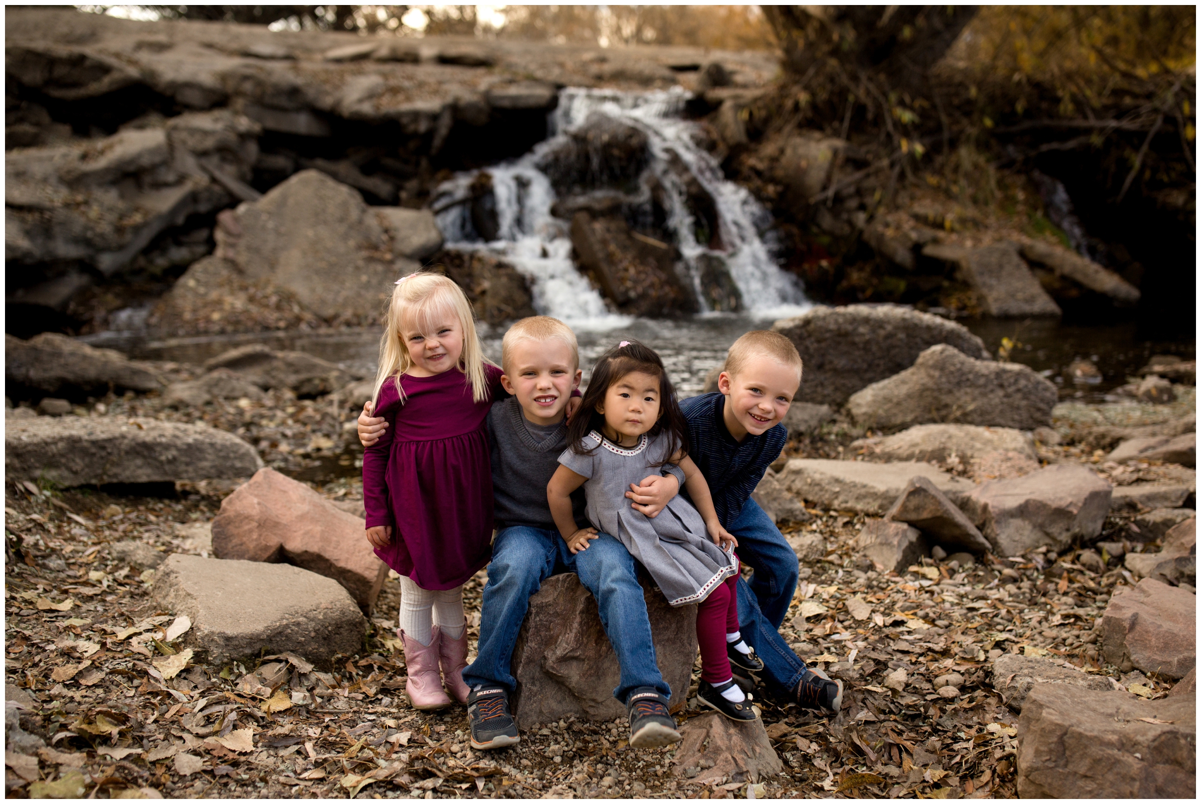 kids sitting by waterfall at Golden Ponds Longmont family pictures 