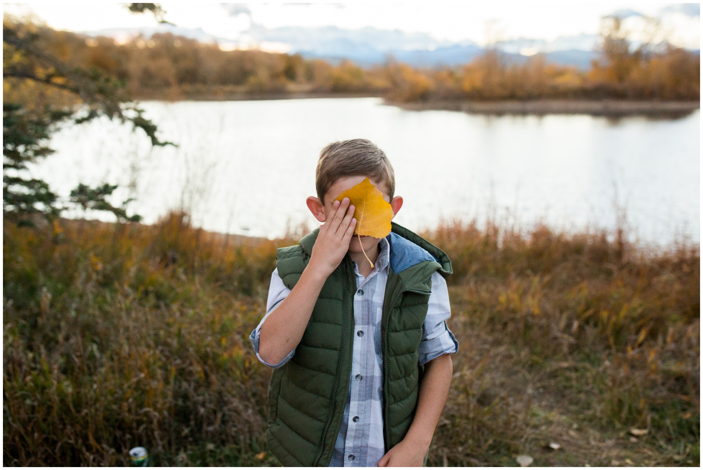 kid blocking his face with huge leaf at Golden Ponds Longmont 