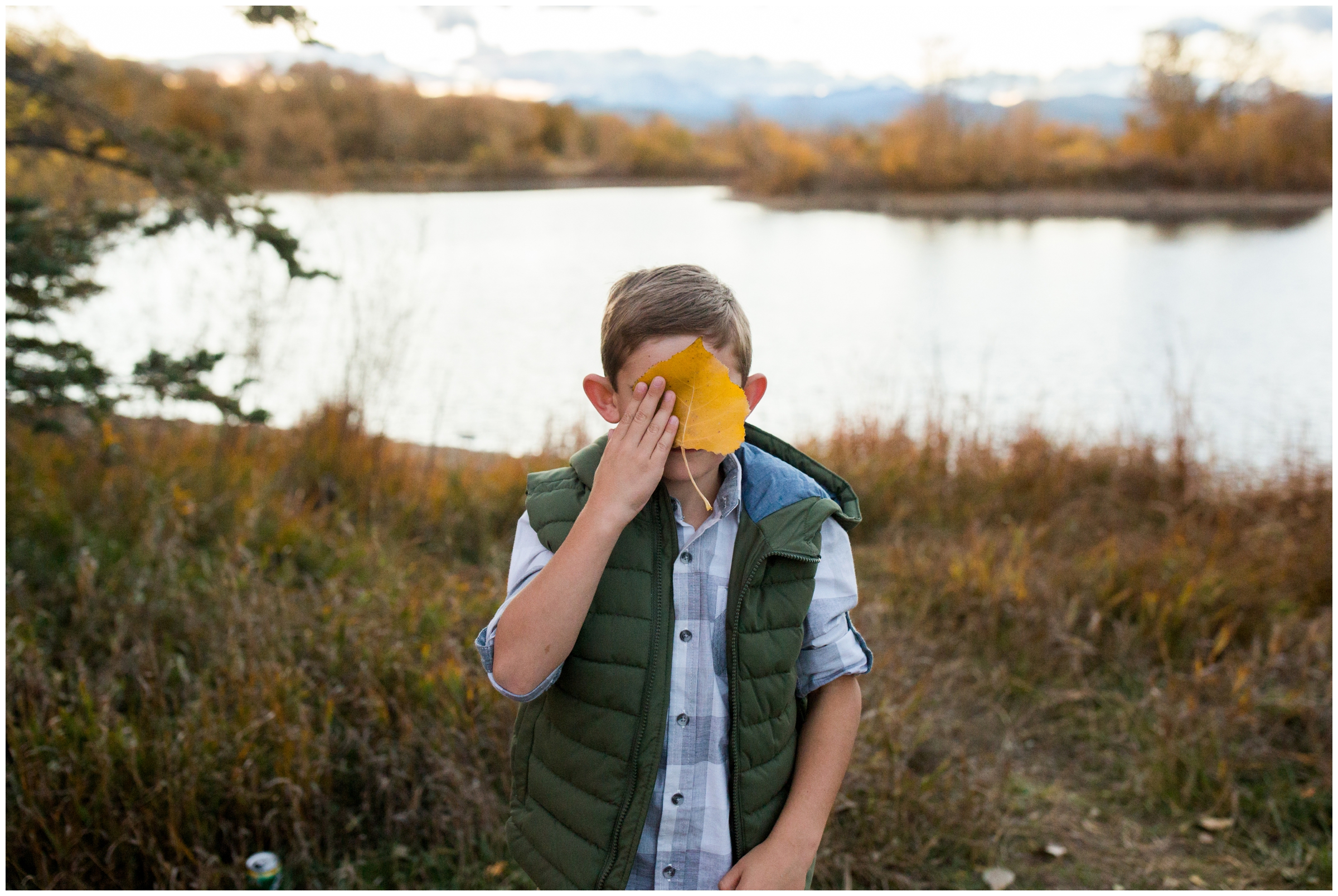 kid blocking his face with huge leaf at Golden Ponds Longmont
