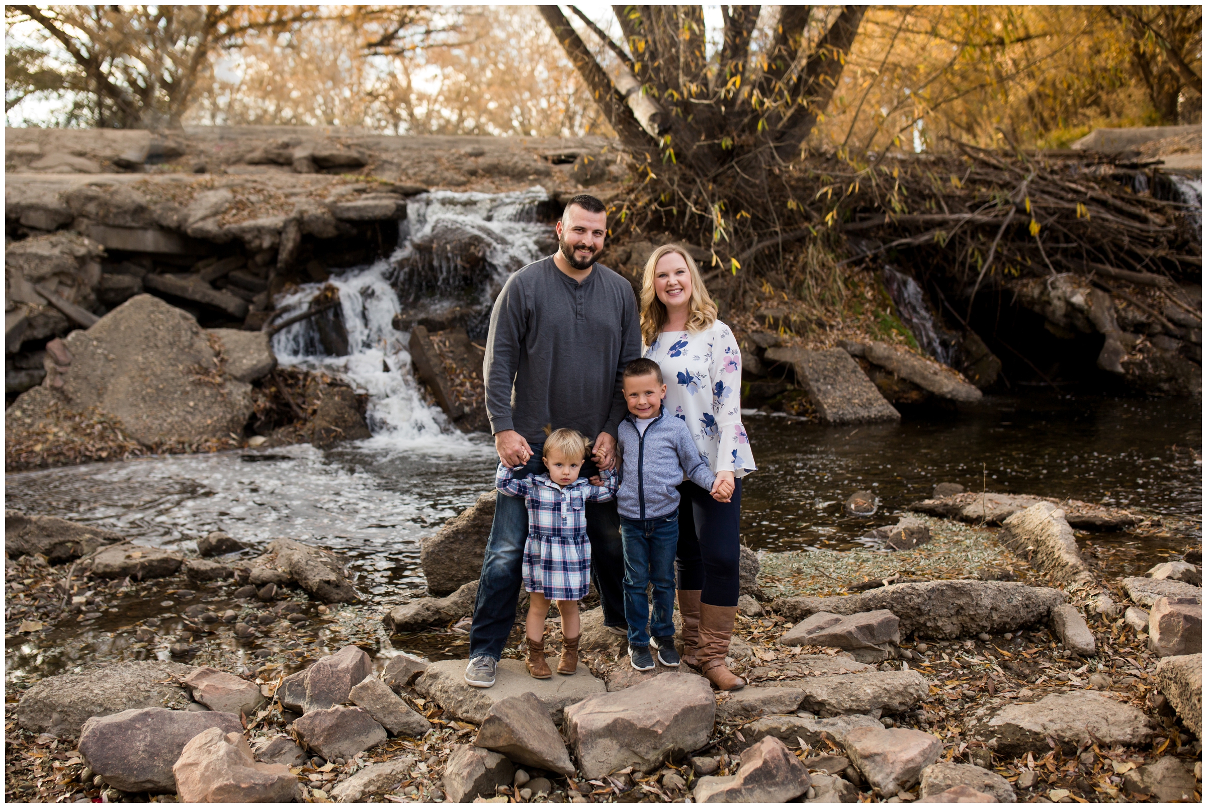family posing by waterfall at Golden Ponds 