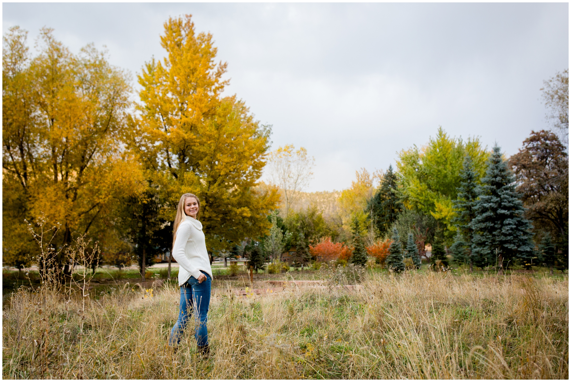 teen standing in field with colorful fall foliage in background in Lyons Colorado 