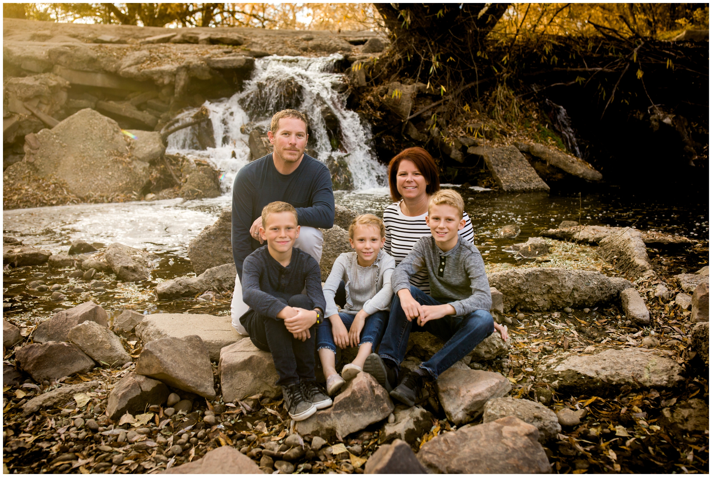 family posing by waterfall at Boulder County Colorado family photography session