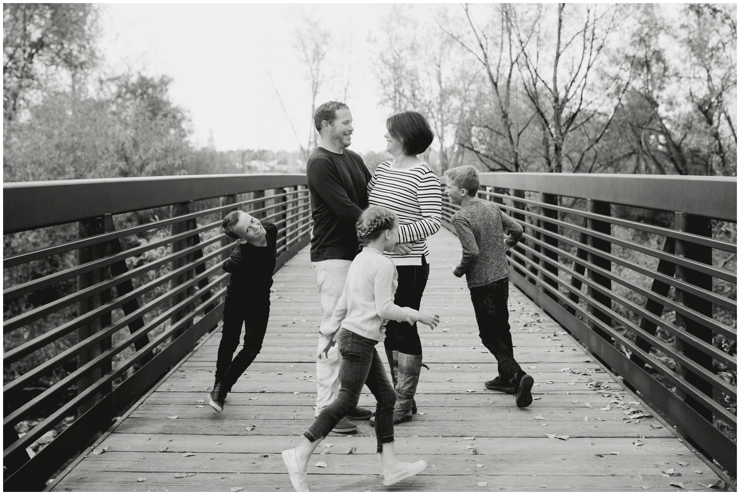 kids running on bridge during Longmont Colorado family portraits at Golden Ponds Nature Area
