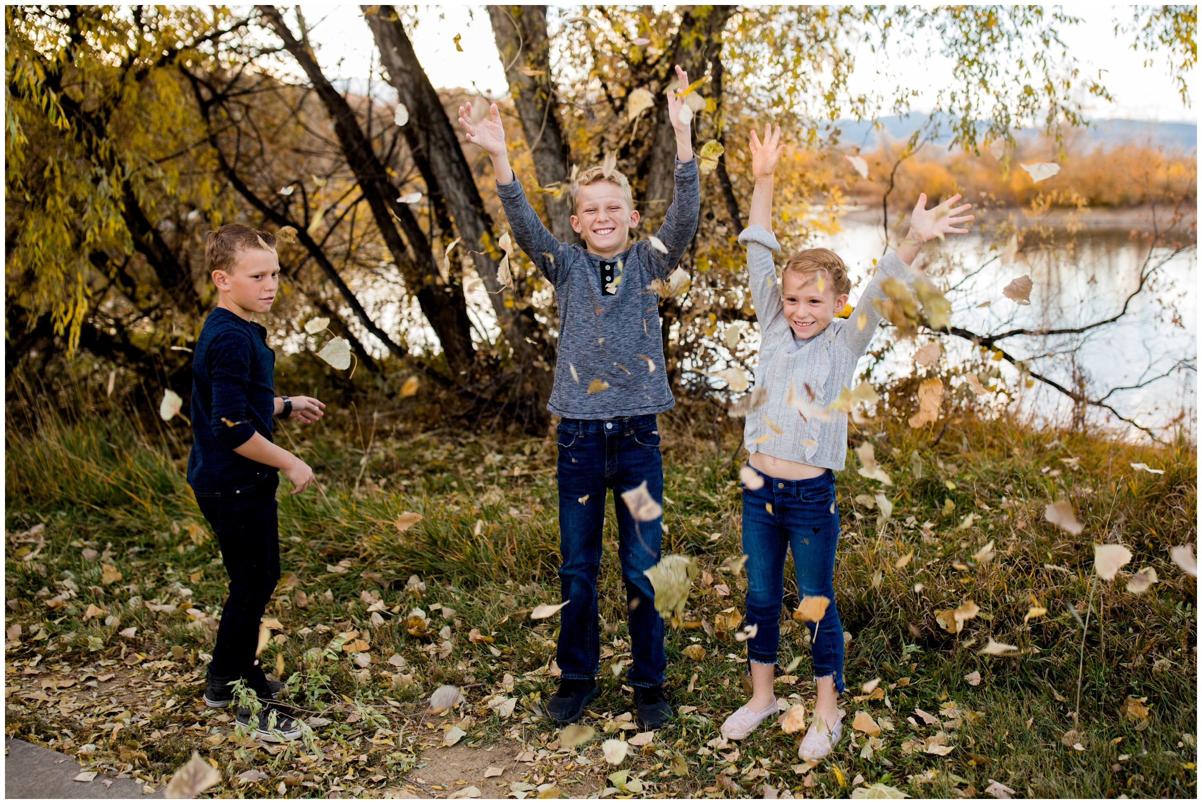 kids throwing leaves during Boulder County Colorado fall family photos at Golden ponds Longmont 