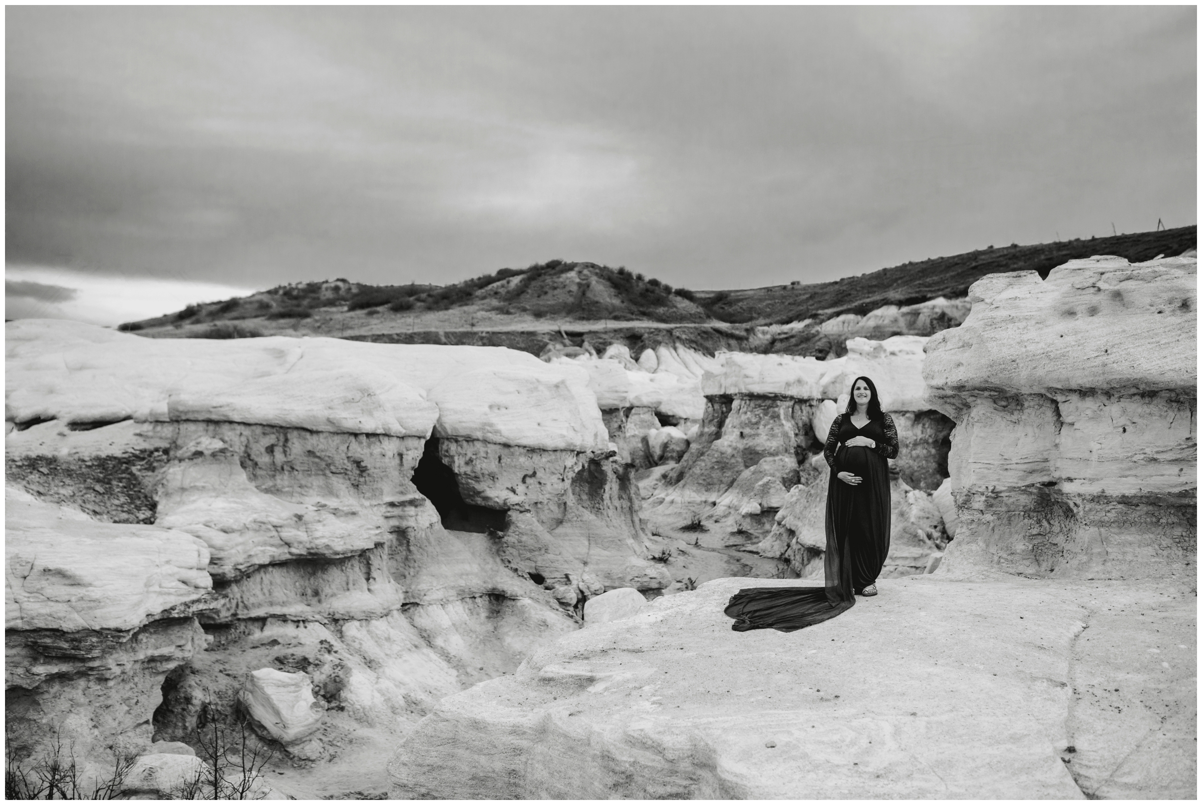 pregnant woman standing on rock formations during Colorado Springs maternity pictures 
