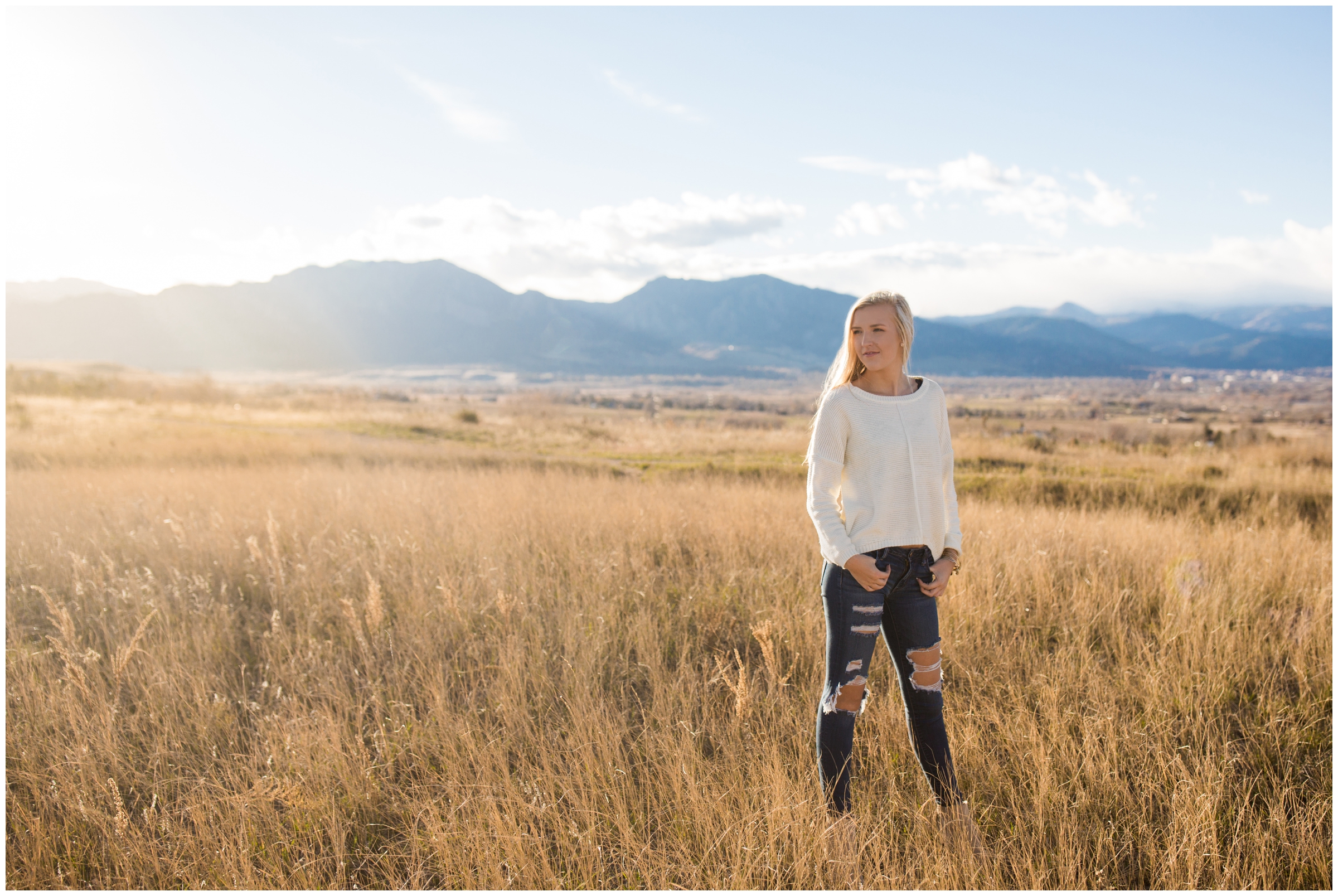 high school student standing in open field during Boulder Colorado senior photography session 