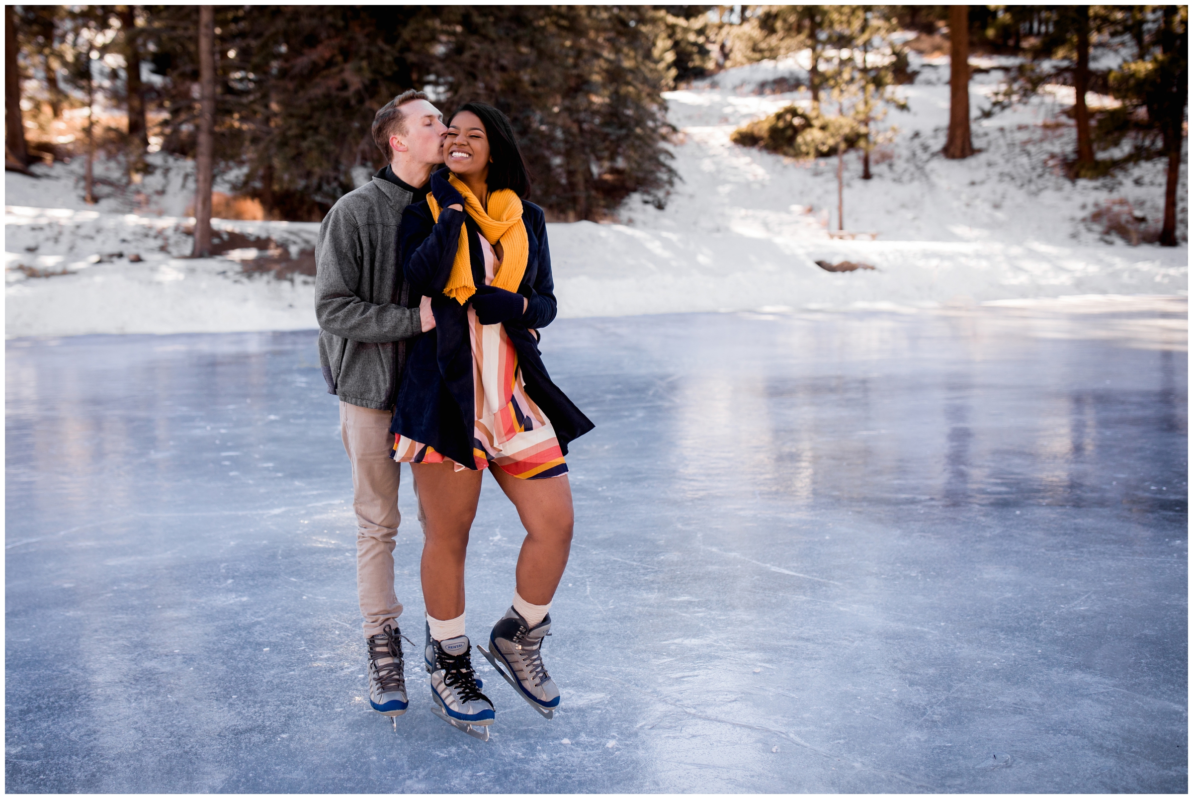 couple posing on frozen mountain lake during Colorado ice skating engagement photography session 