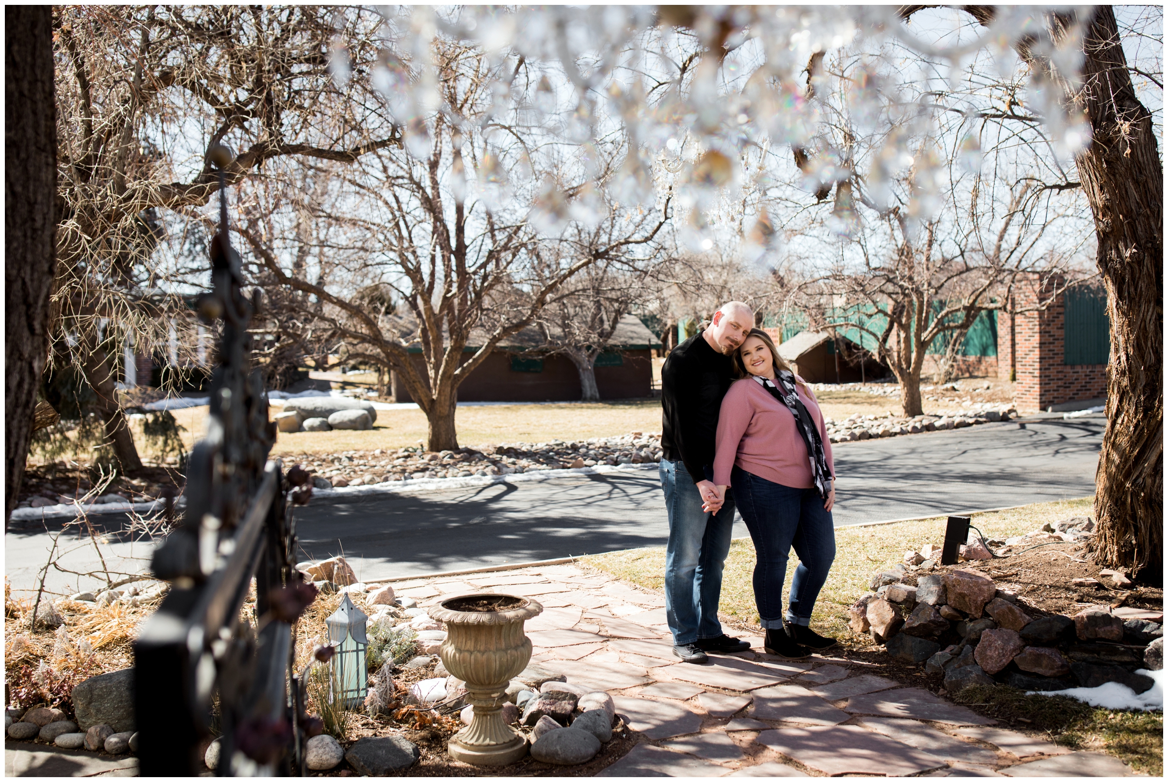 bride and groom posing under outdoor chandelier at Lionsgate Event Center engagement photos