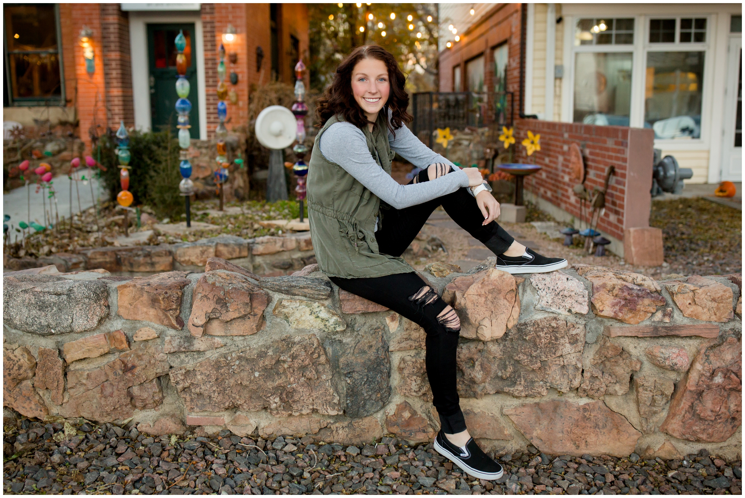 Niwot High School student sitting on stone wall for Colorado urban senior pictures 