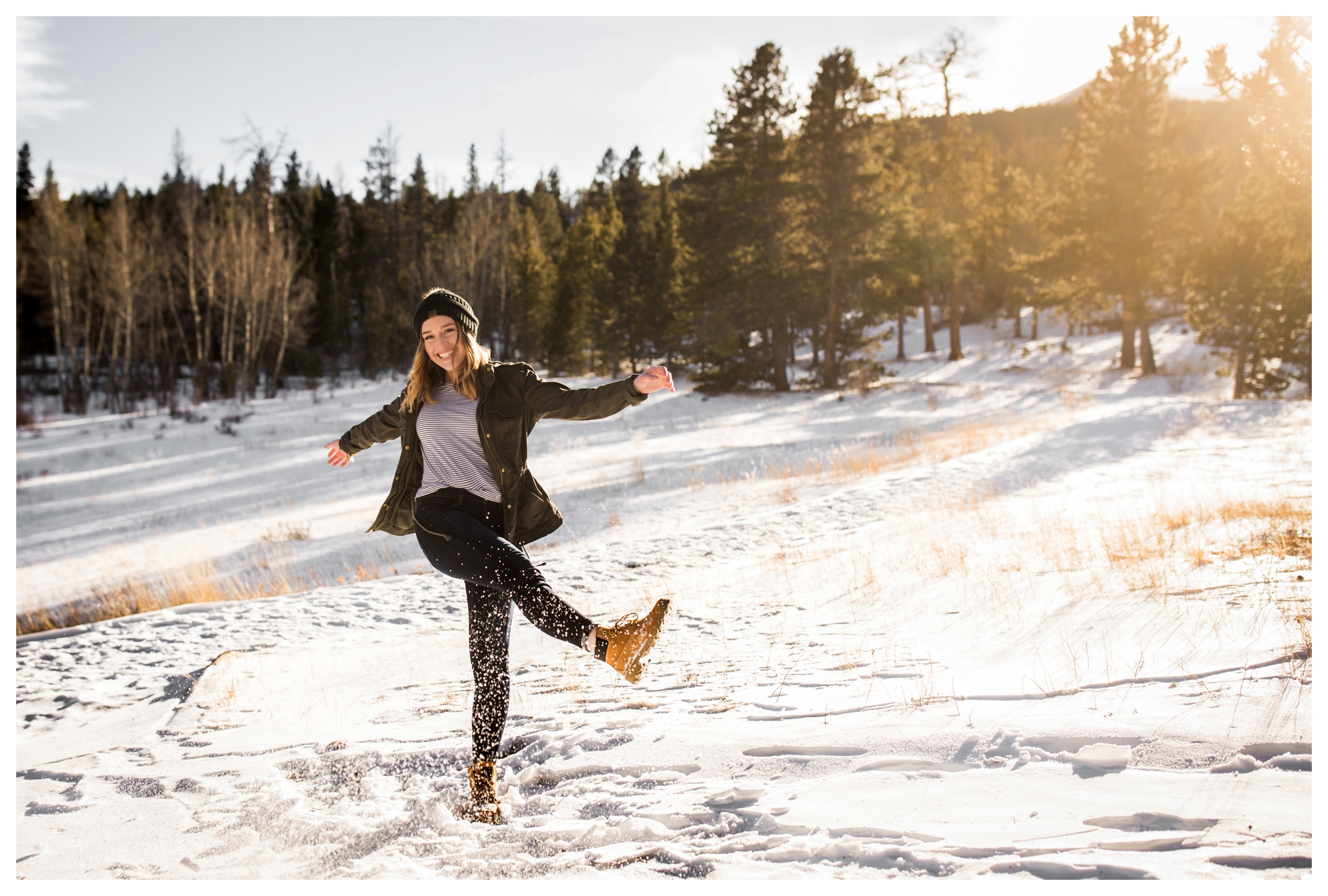 teen kicking snow during Estes Park Colorado winter senior pictures 
