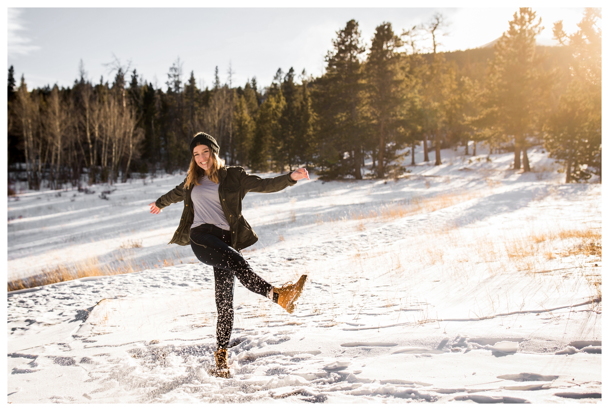 teen kicking snow during Estes Park Colorado winter senior pictures