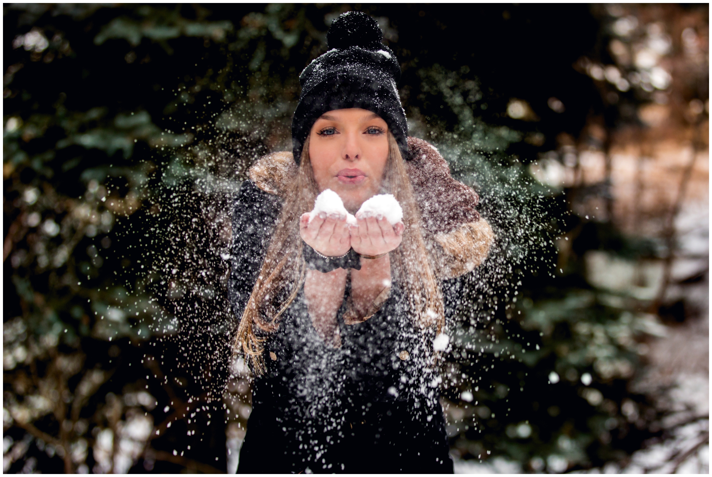 girl blowing snow towards camera at Colorado winter senior photos at YMCA of the Rockies Estes park 