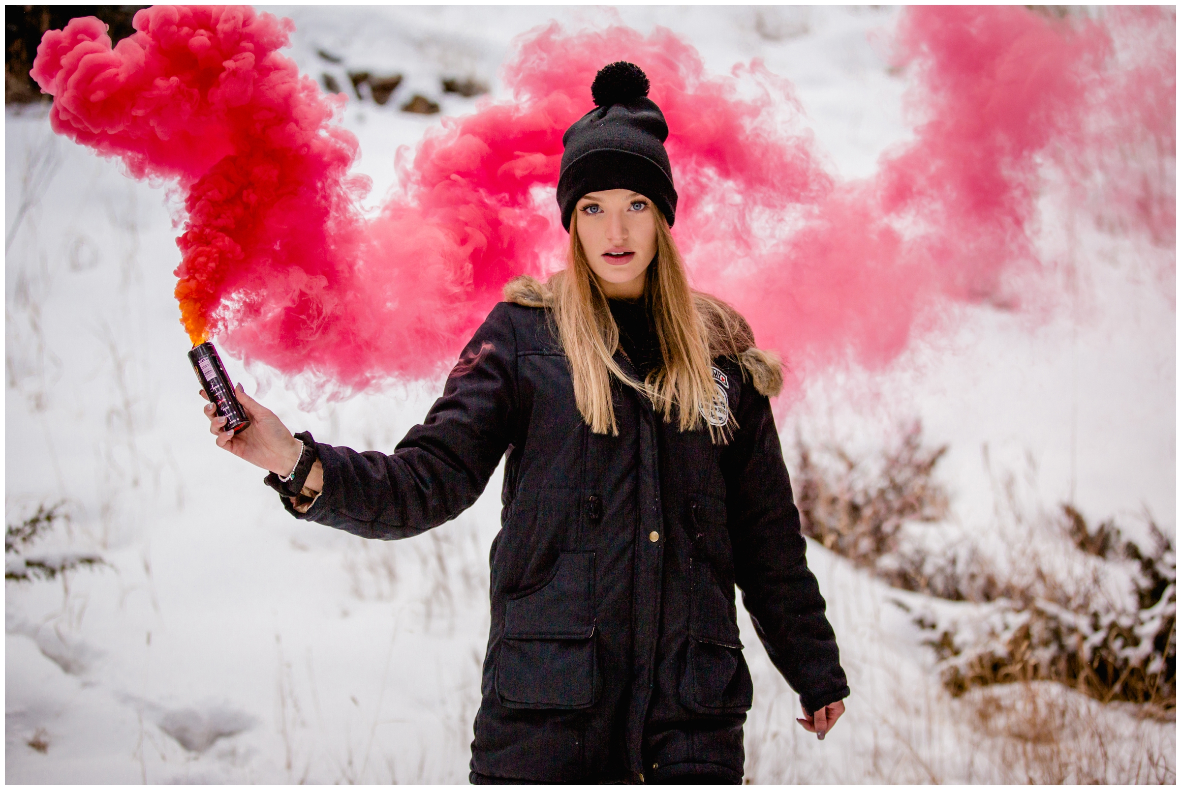 teen girl playing with smoke bomb in the snow